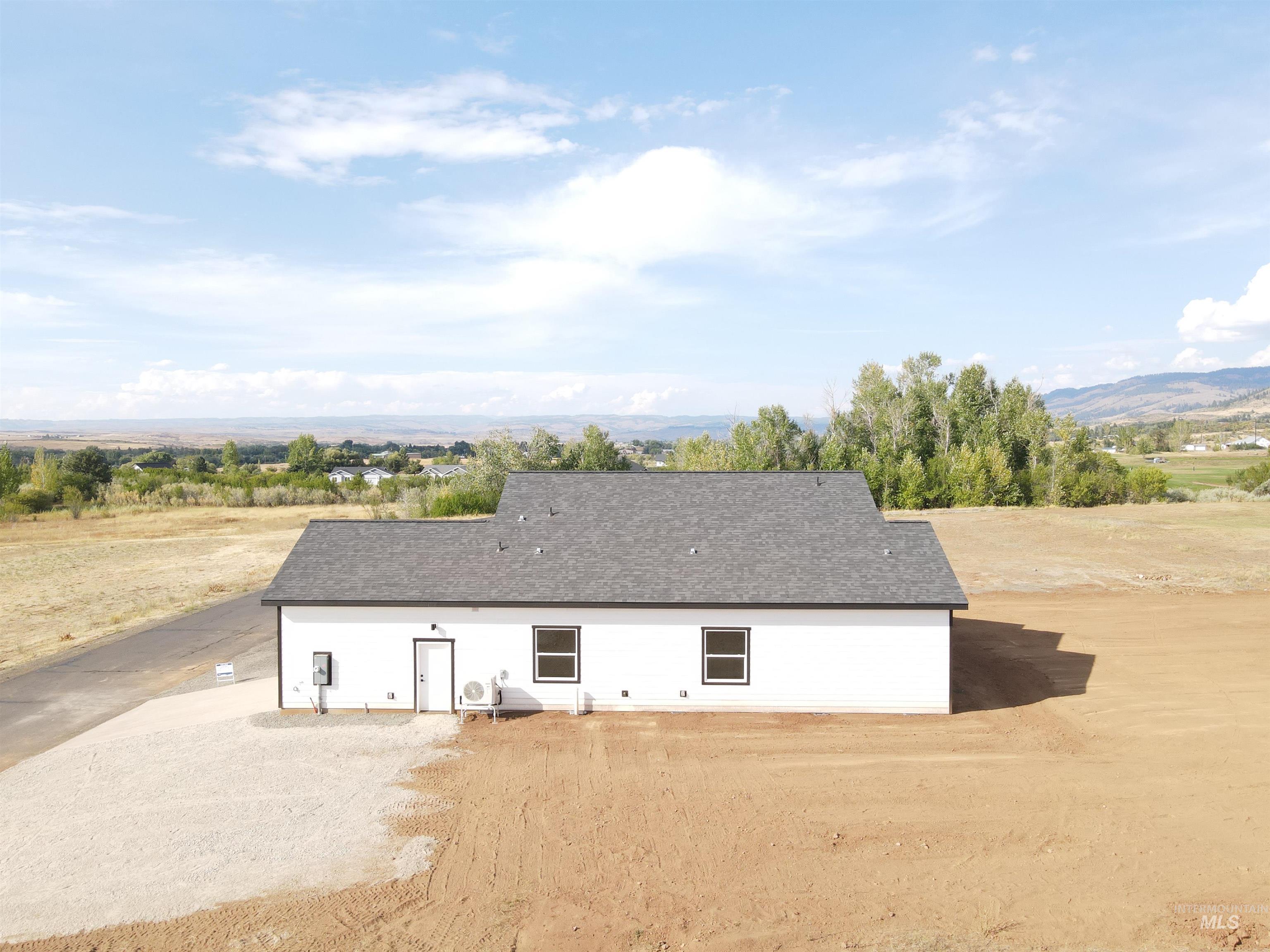 Rear view of house with roof with shingles and a mountain view