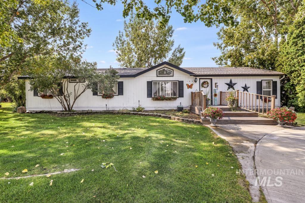 View of front of home with a front lawn and a shingled roof