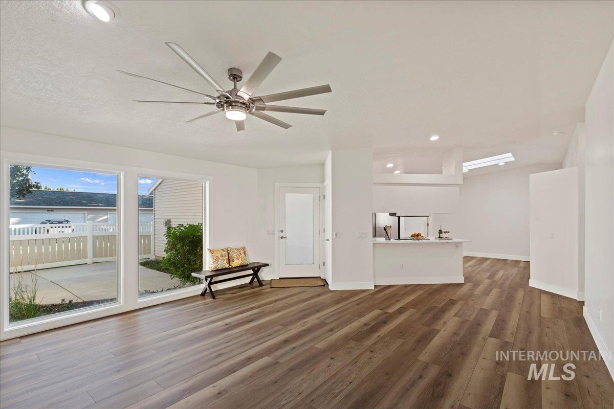 Unfurnished living room featuring recessed lighting, dark wood-style flooring, and a ceiling fan