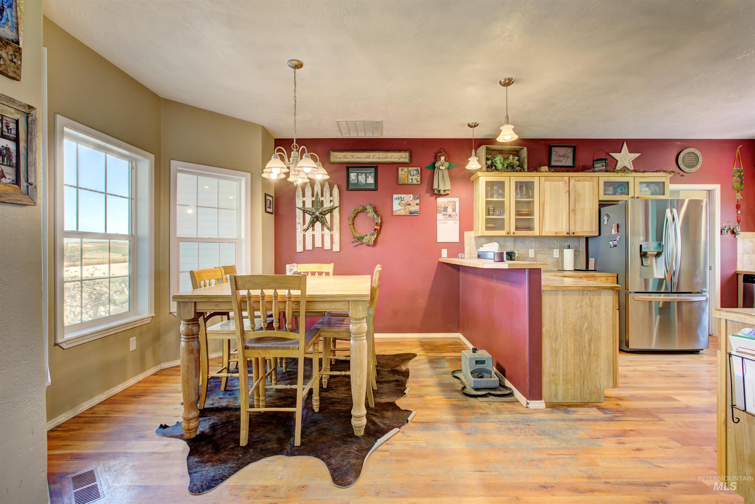 Dining area with light wood-style floors and a chandelier