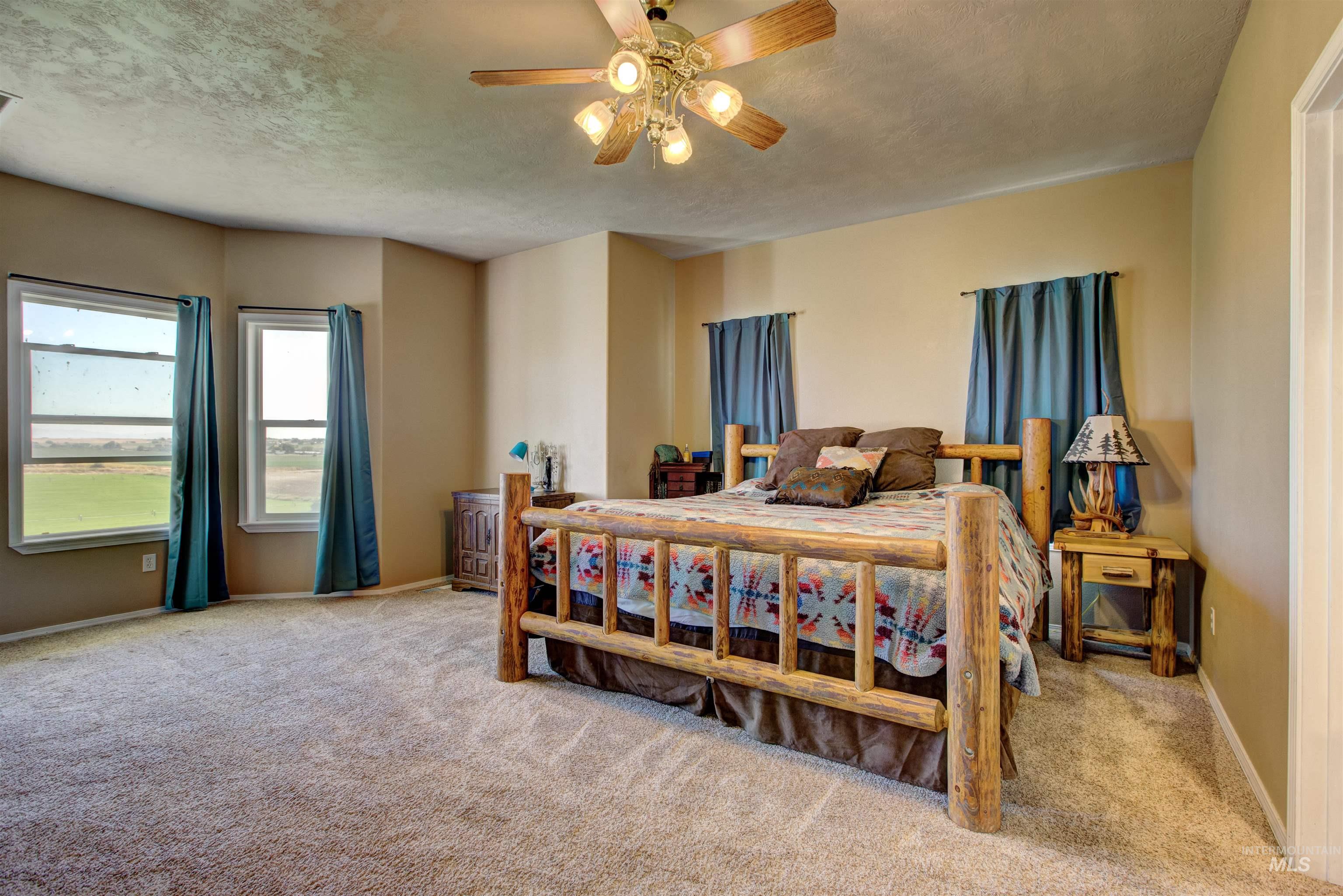 Carpeted bedroom featuring a ceiling fan and a textured ceiling