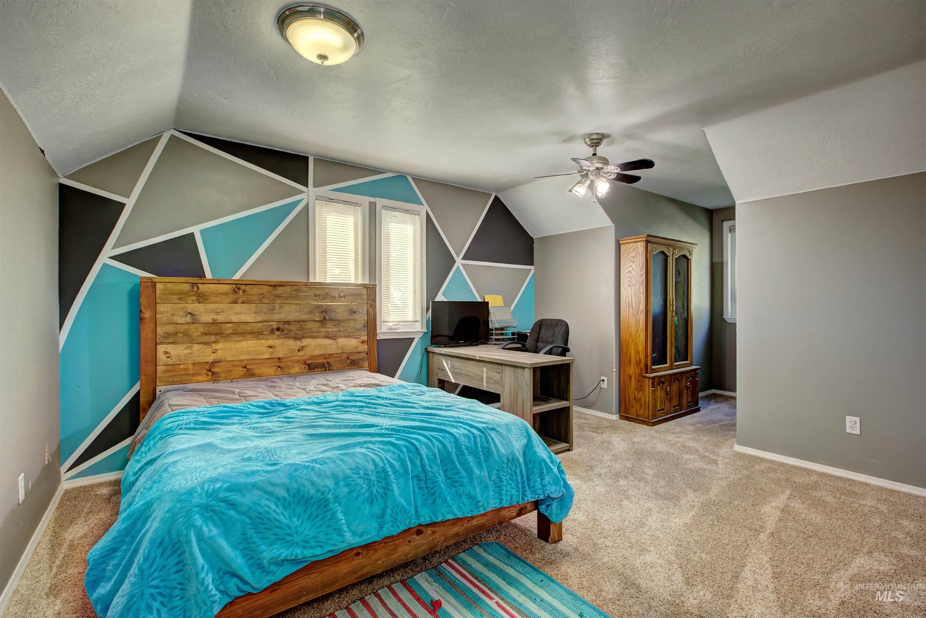 Bedroom with carpet floors, lofted ceiling, a textured ceiling, and ceiling fan