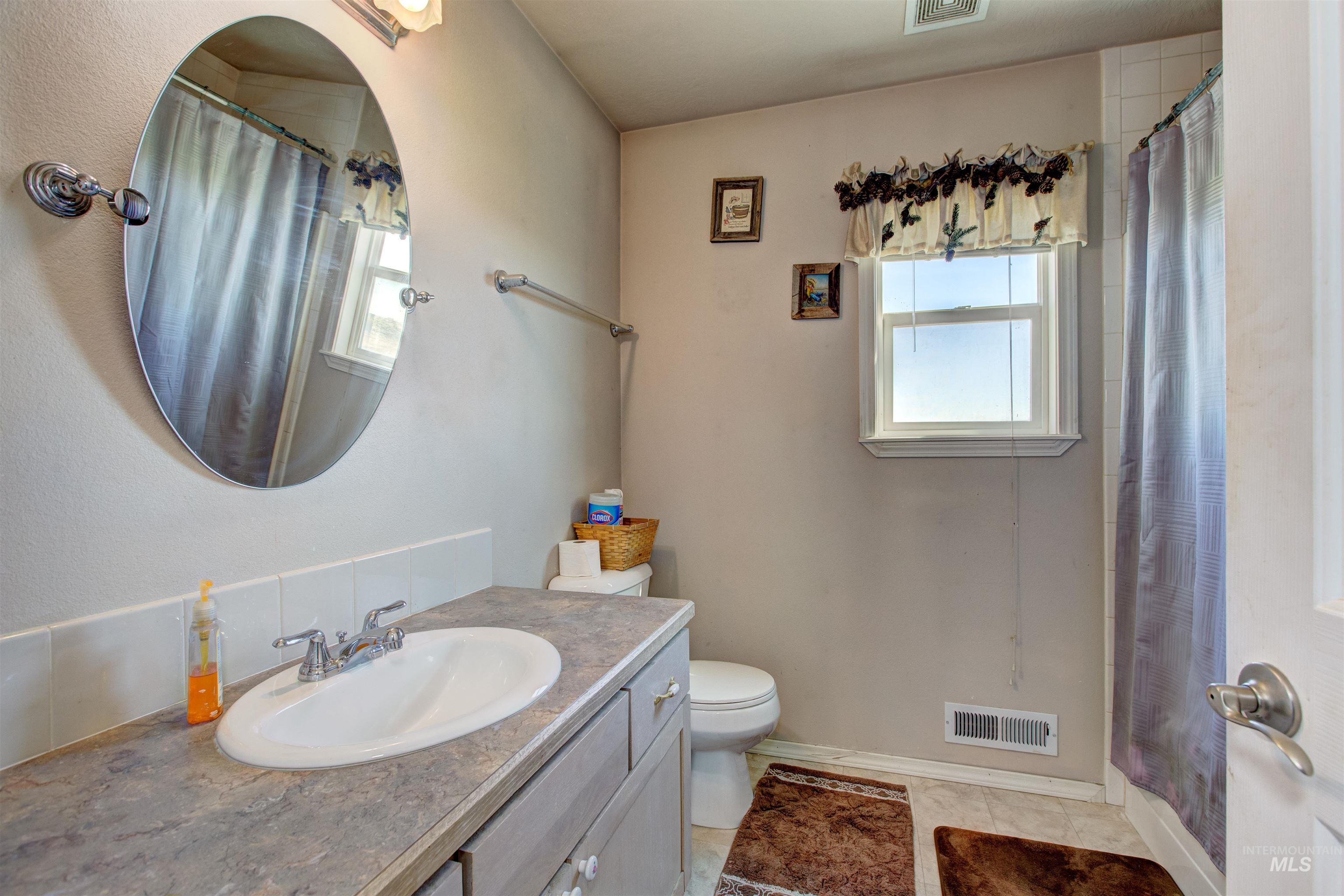 Full bath with vanity, light tile patterned floors, and a shower with shower curtain
