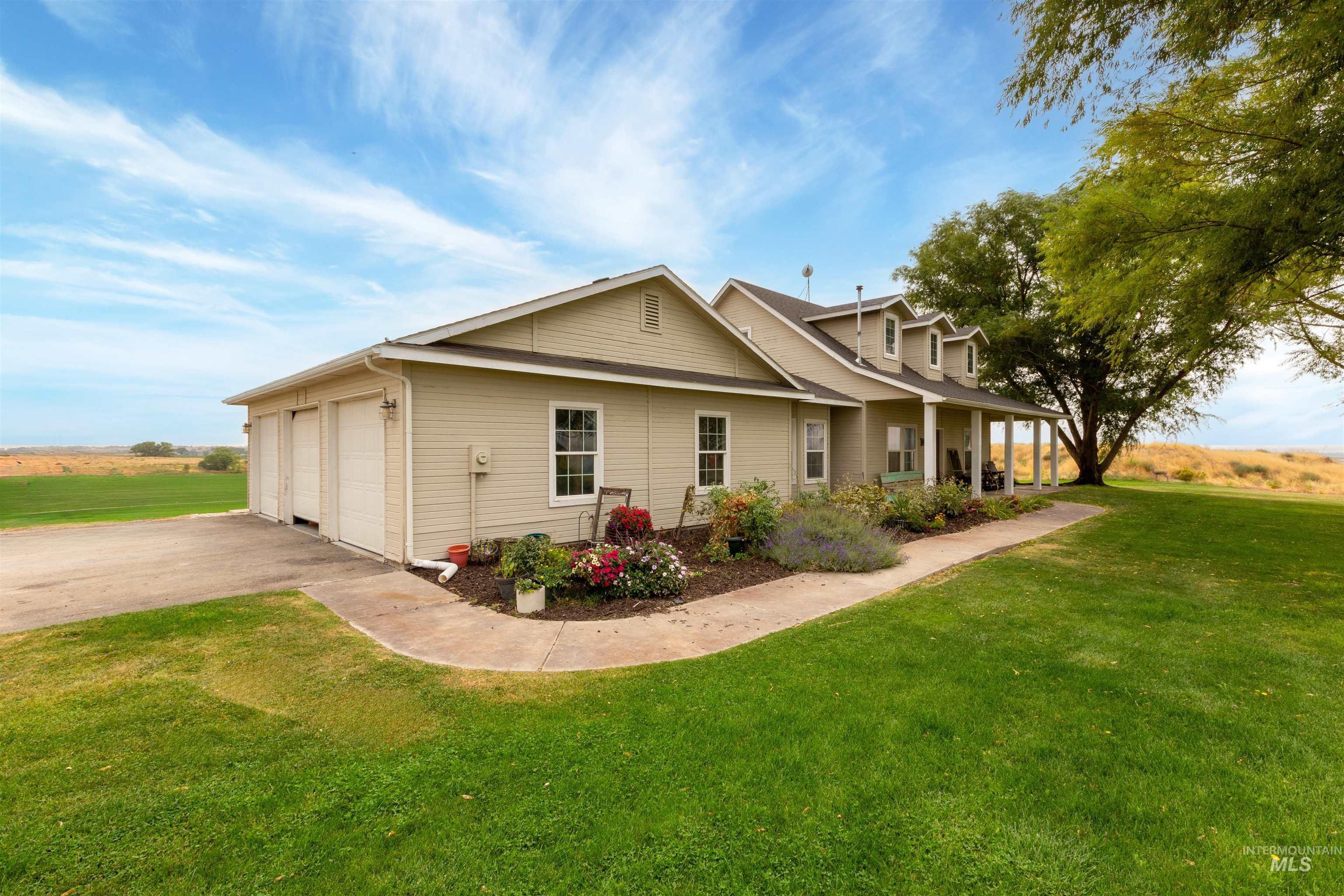 View of front of property featuring a porch, a front yard, a garage, and driveway