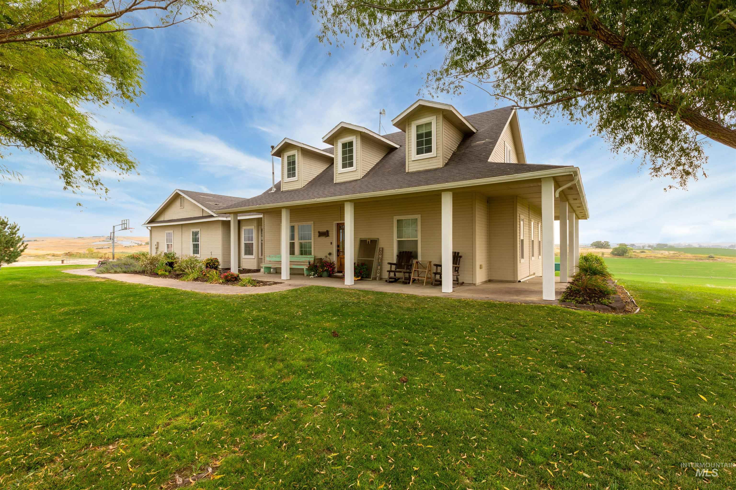 Rear view of property featuring covered porch, a lawn, and roof with shingles