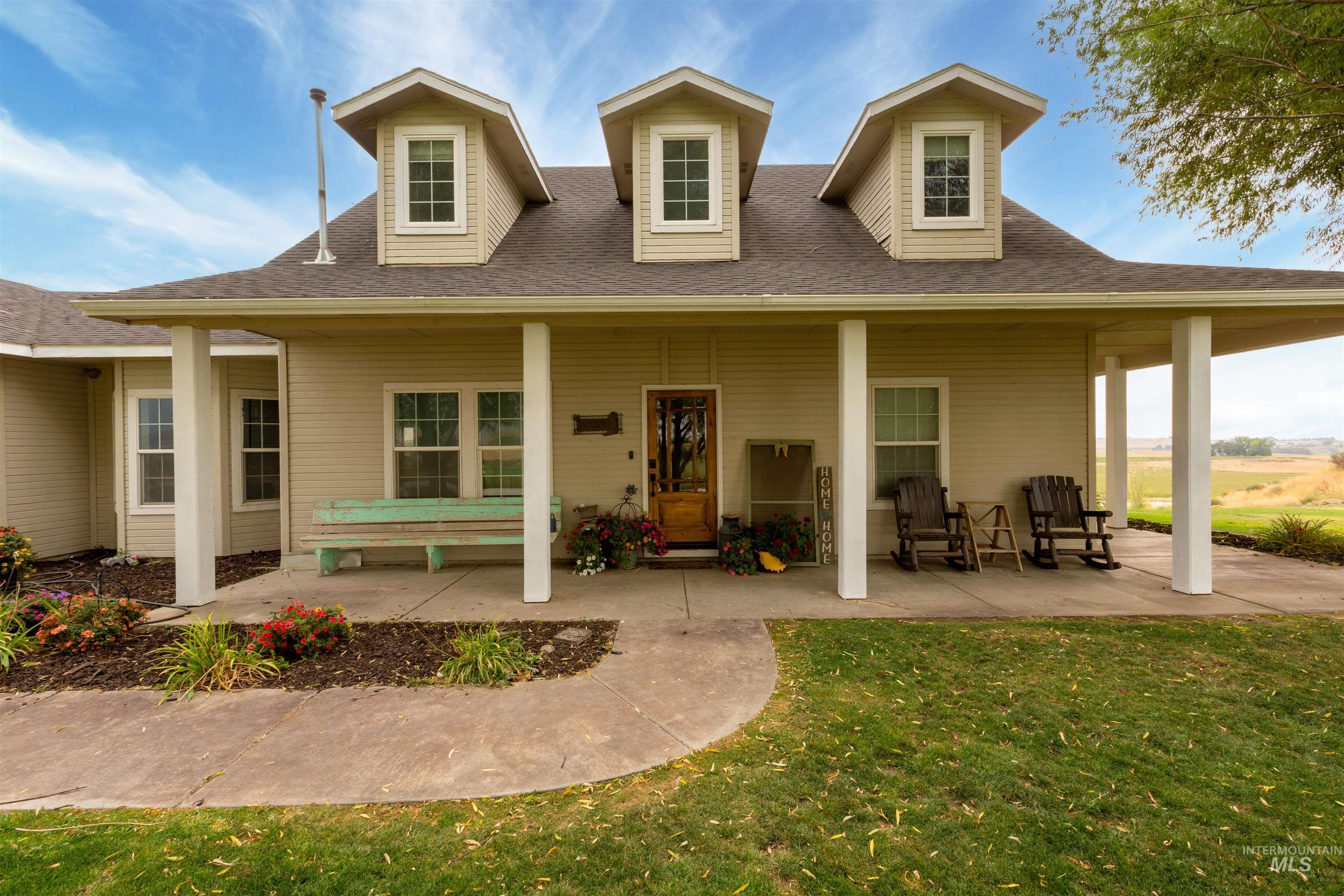 Back of house with covered porch, a lawn, and a shingled roof