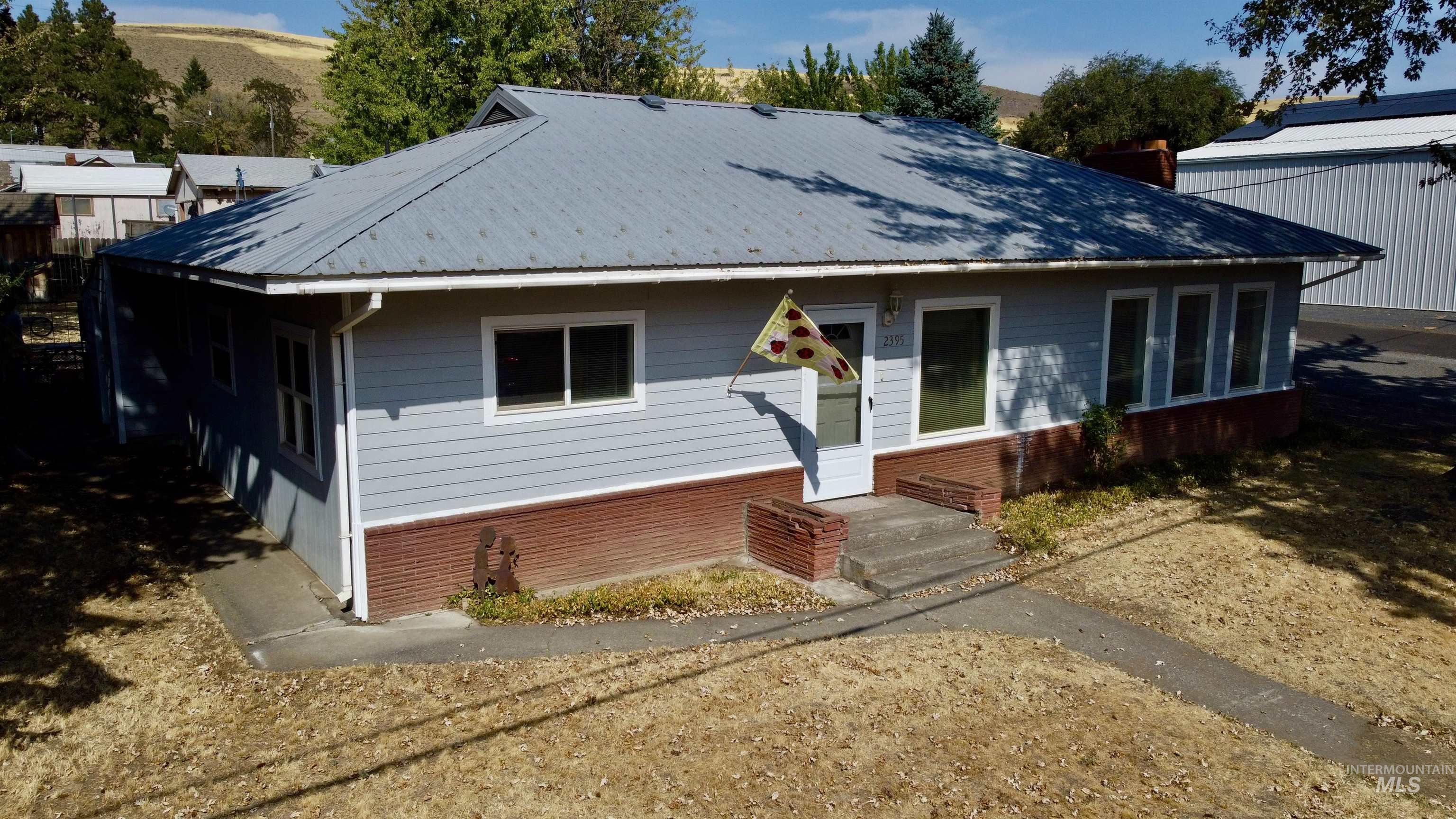 View of front of home with brick siding and a metal roof
