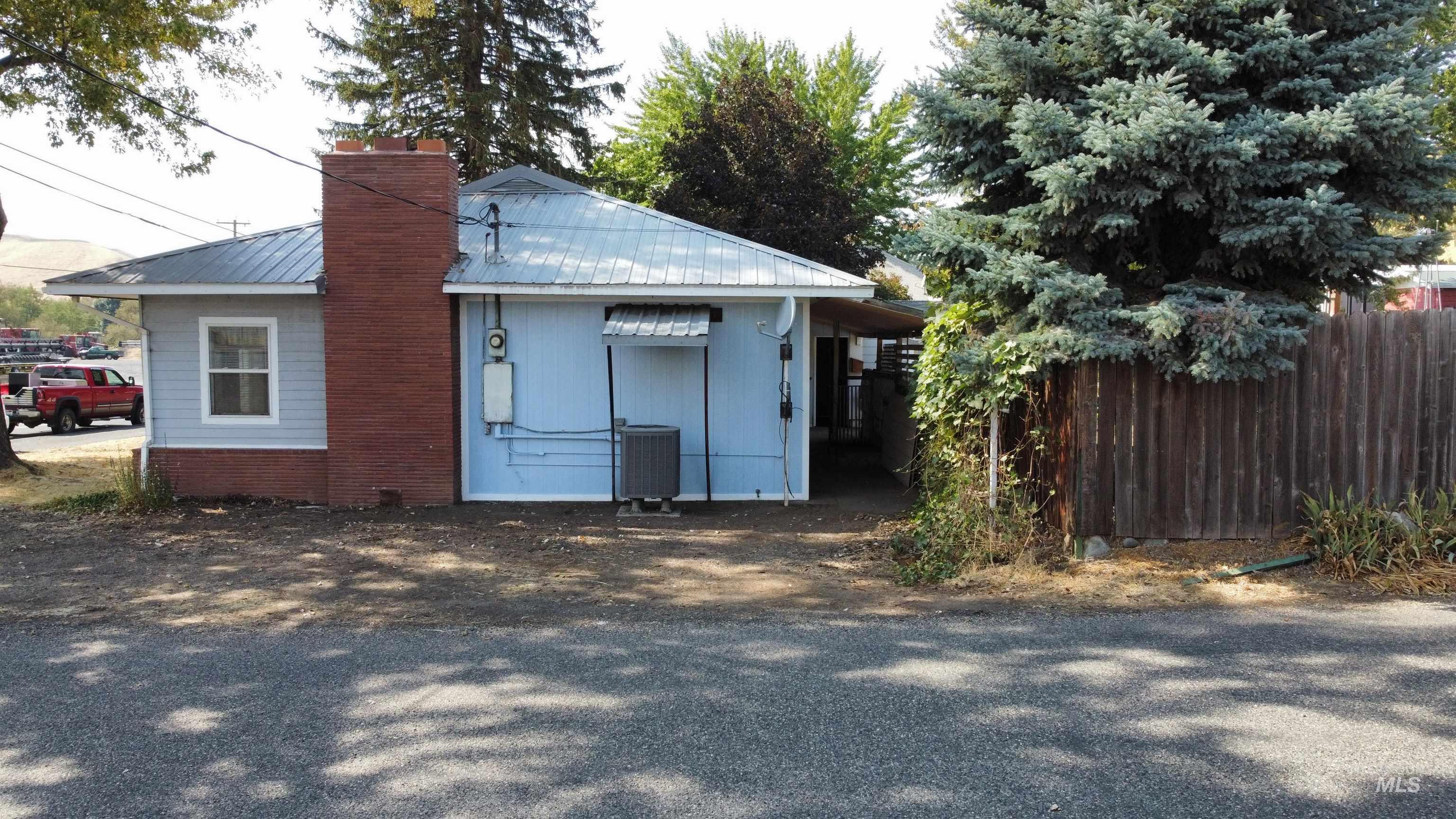 View of property exterior featuring a metal roof and a chimney