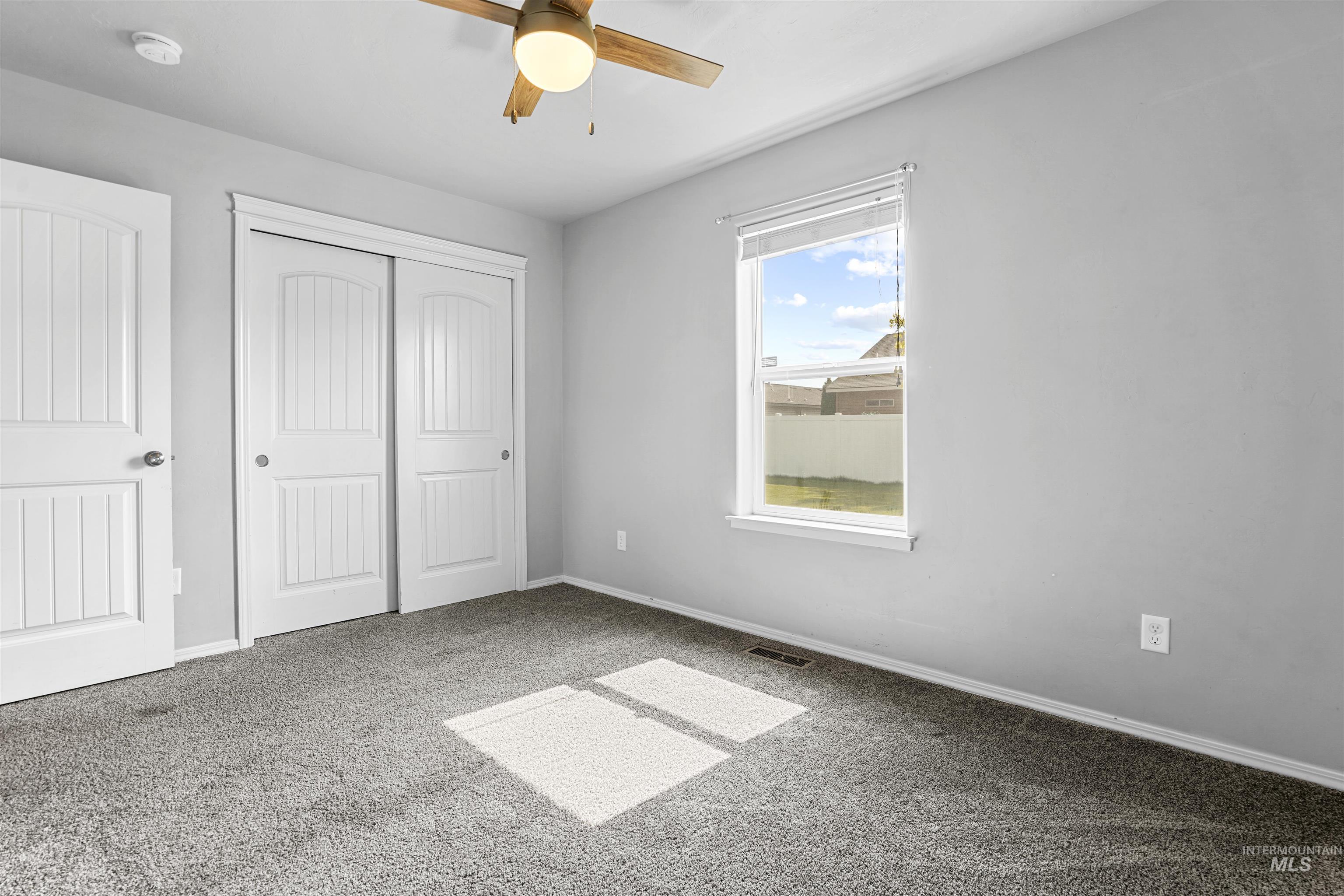 Unfurnished bedroom with carpet, a closet, and ceiling fan