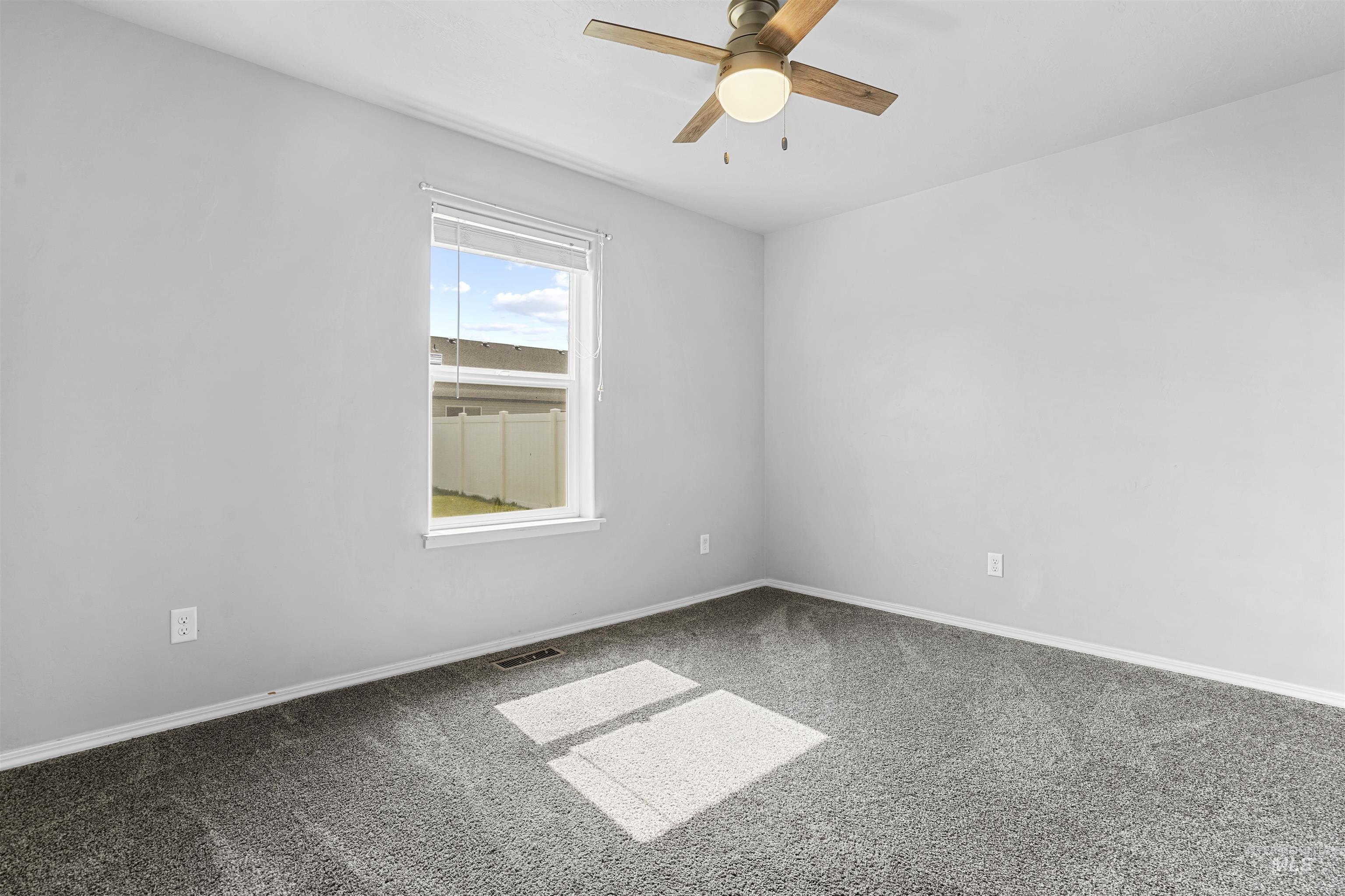 Unfurnished room featuring carpet floors and a ceiling fan