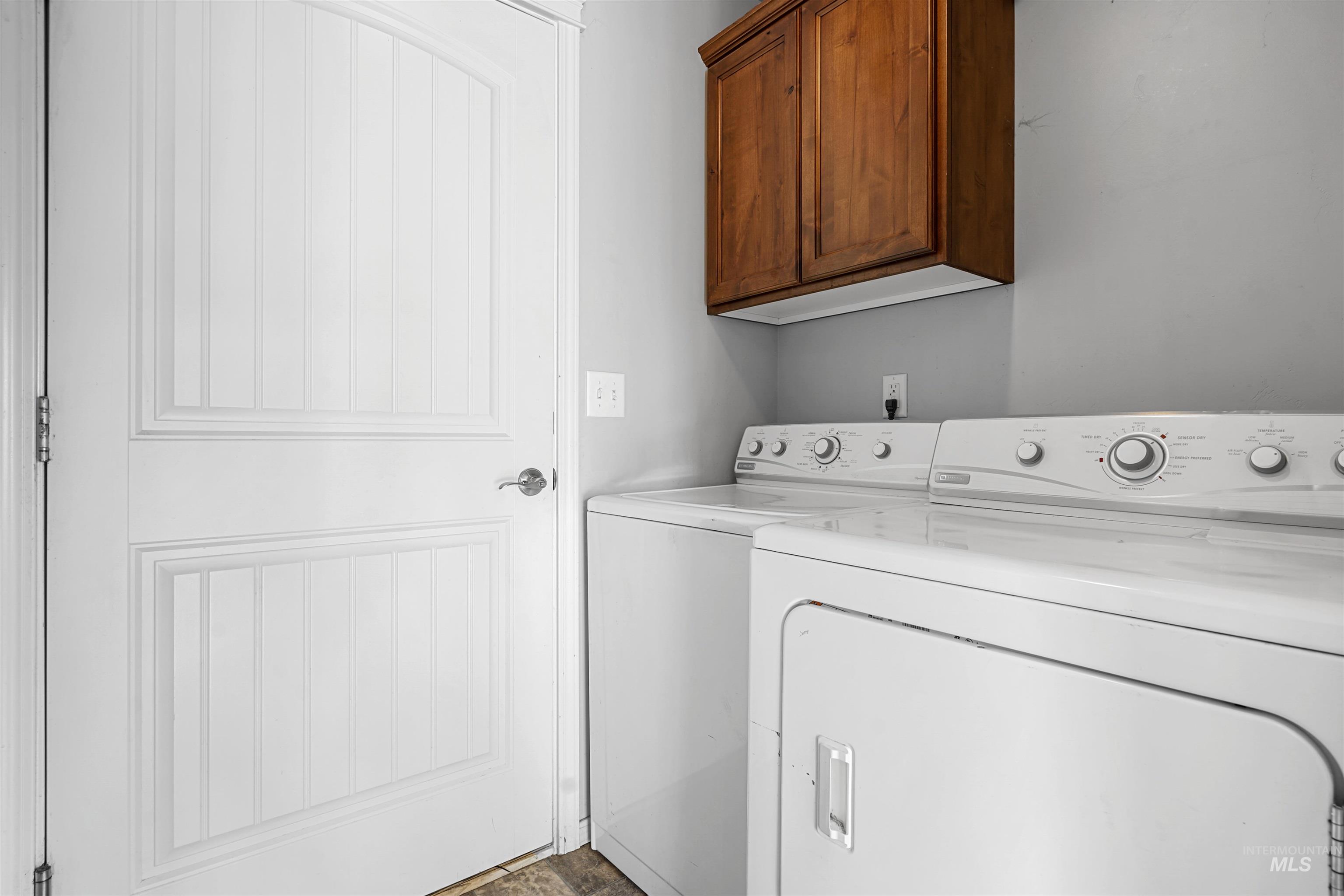 Laundry area featuring independent washer and dryer and cabinet space