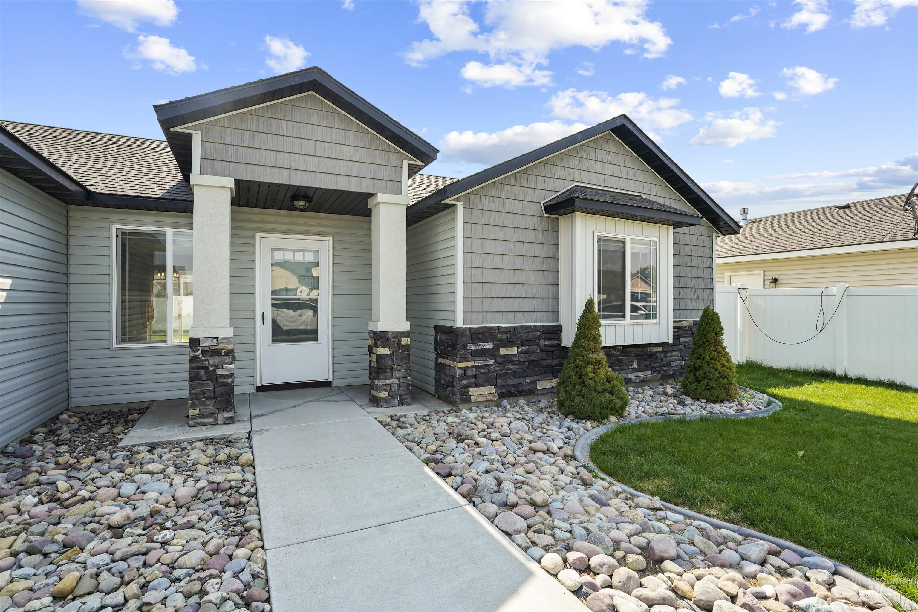 Entrance to property featuring stone siding, board and batten siding, and a shingled roof