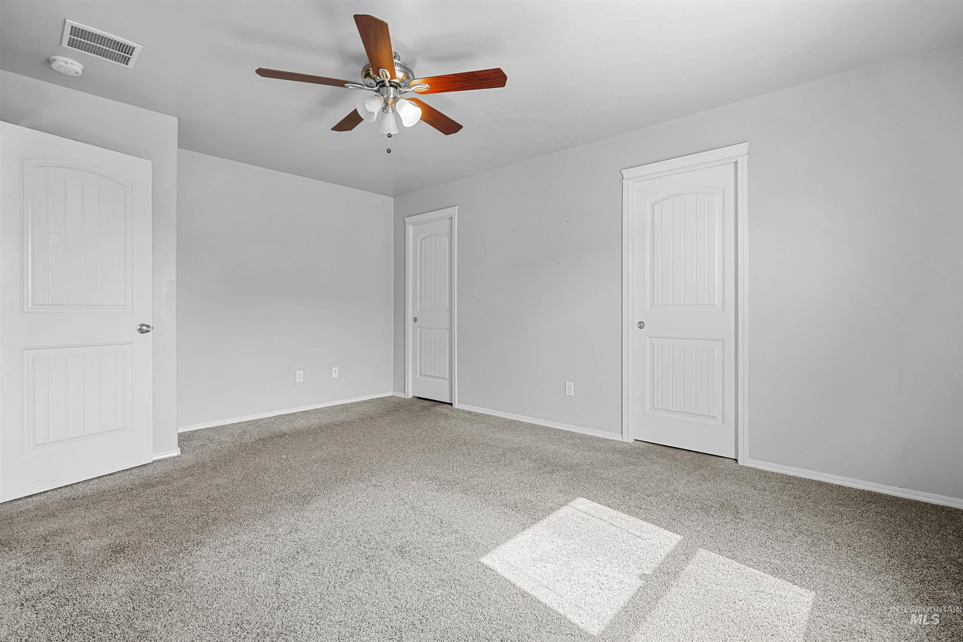 Unfurnished bedroom featuring light colored carpet and a ceiling fan