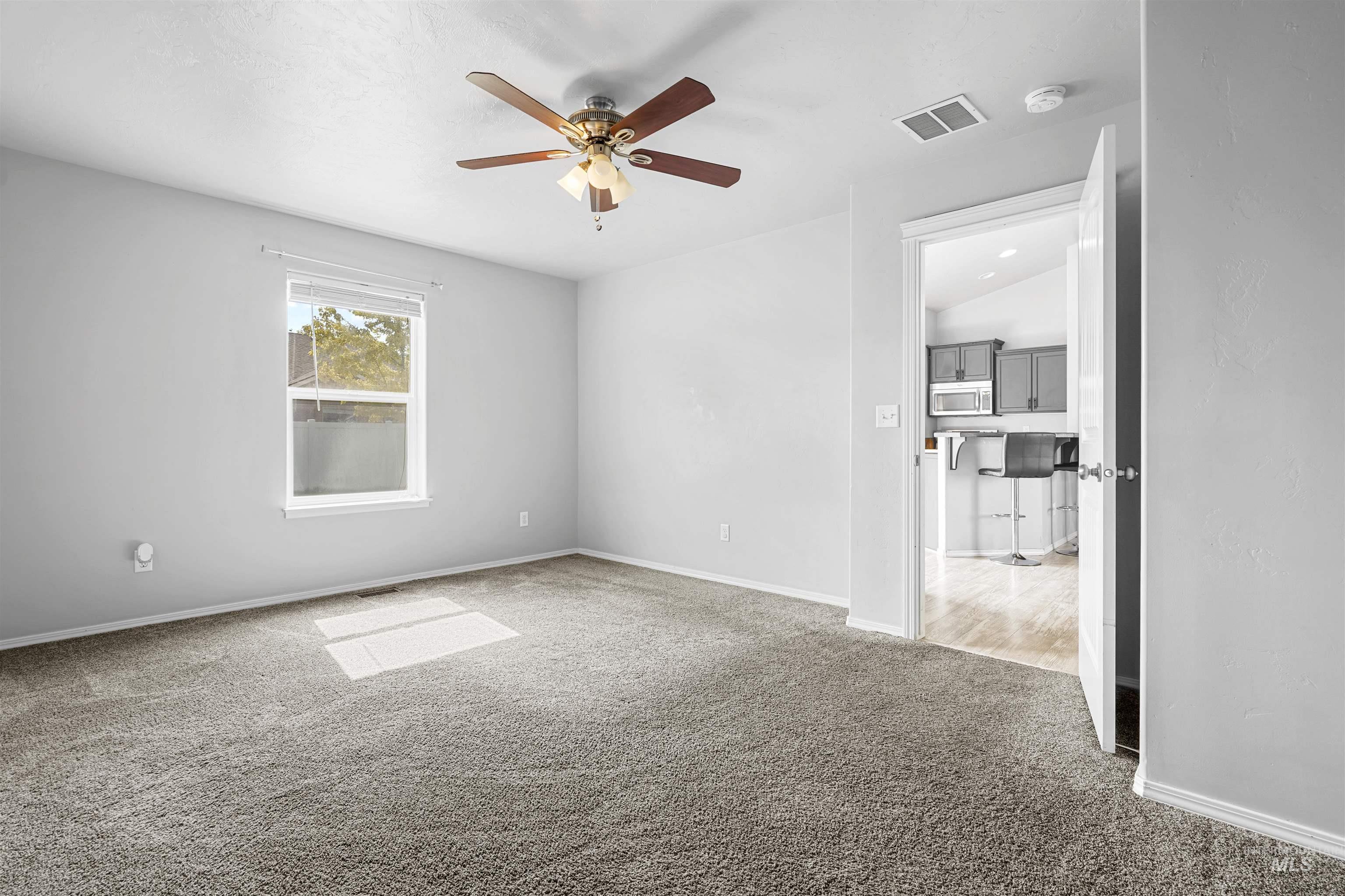 Spare room with light colored carpet and a ceiling fan