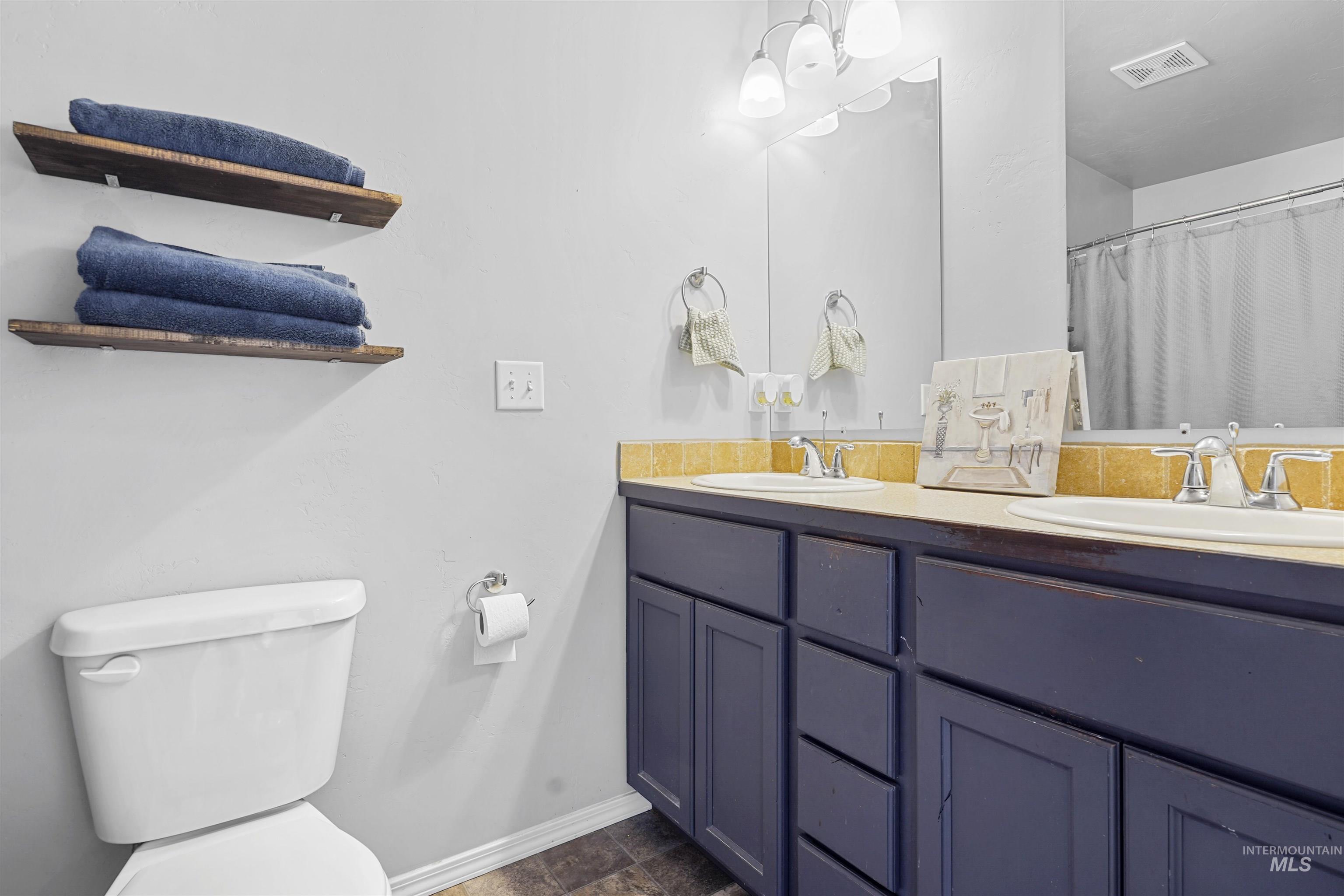 Bathroom featuring double vanity and curtained shower