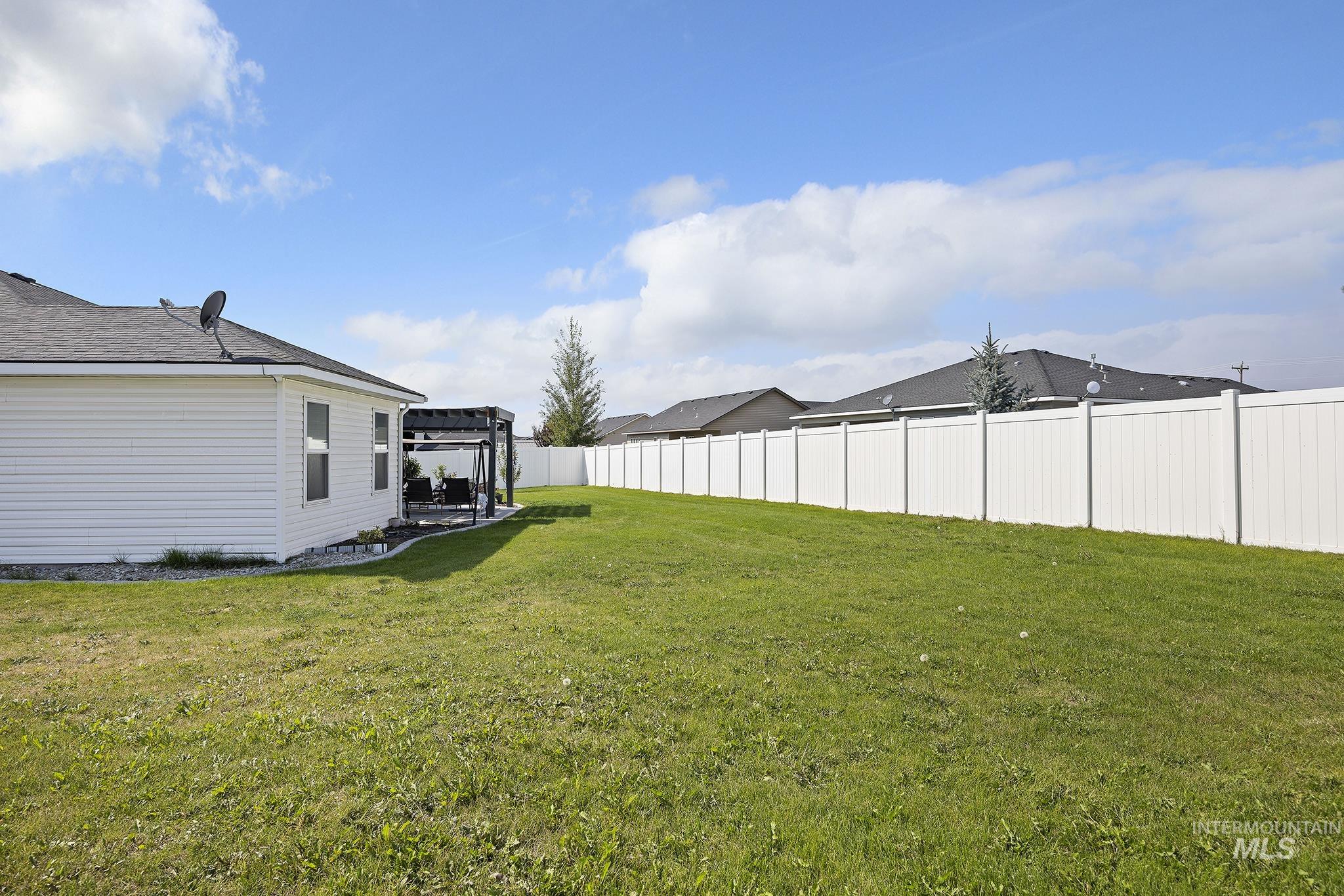 Fenced backyard with a patio and a pergola