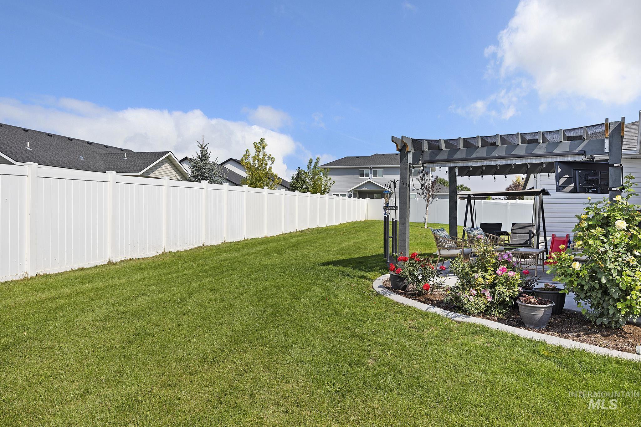 View of yard featuring a pergola, a patio area, and a residential view