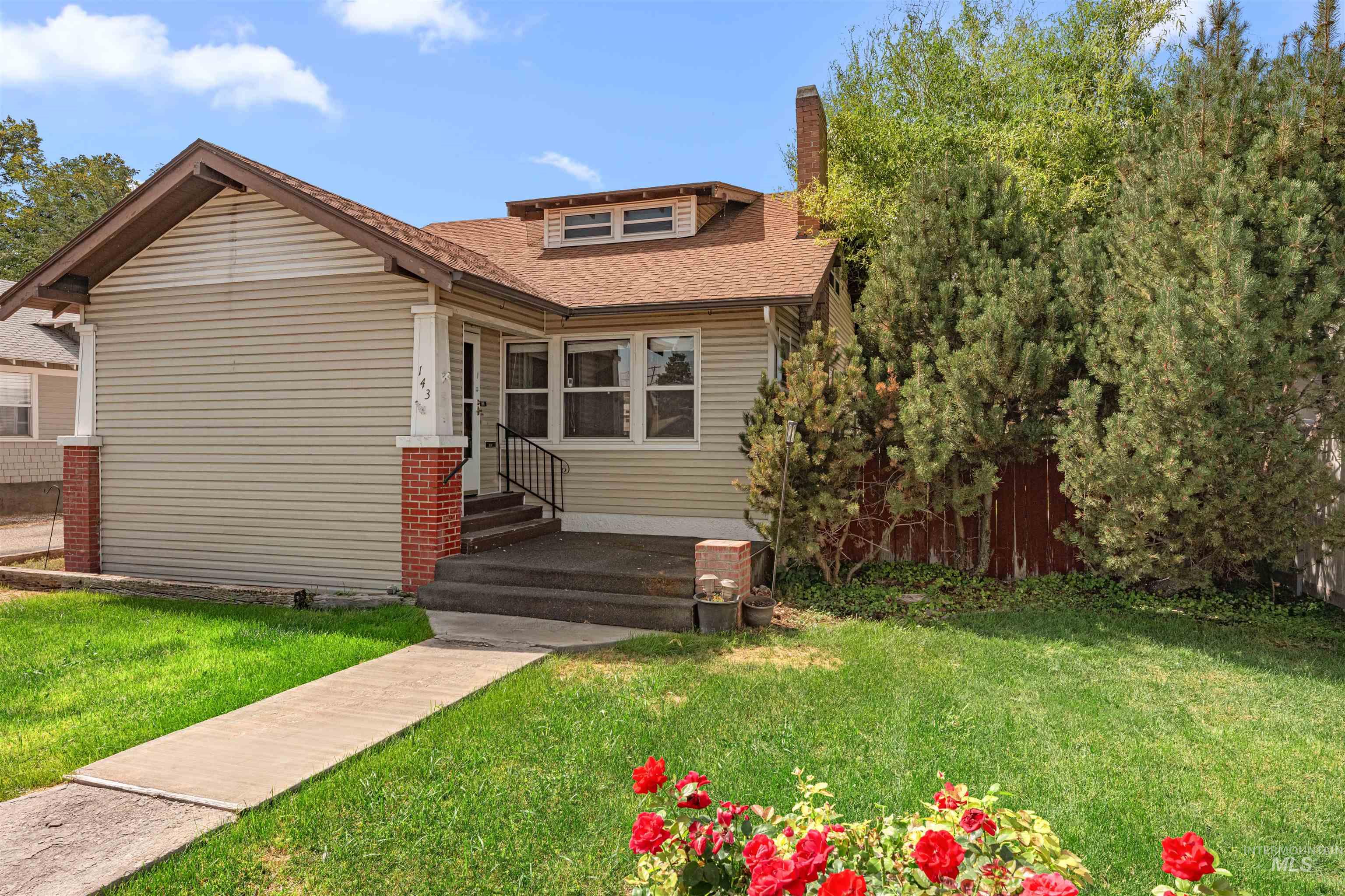 Bungalow with a front yard, roof with shingles, a chimney, and entry steps