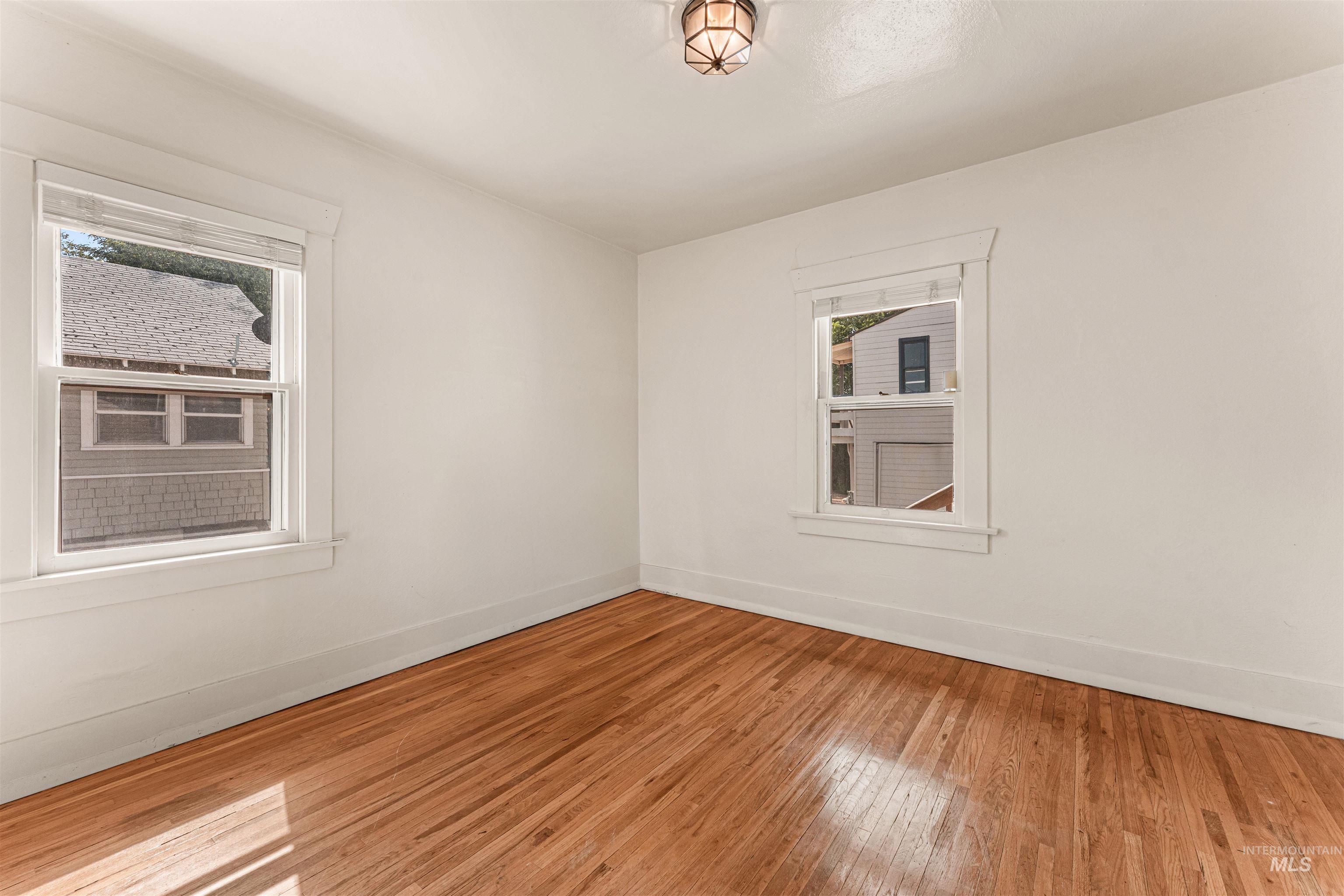 Empty room featuring hardwood / wood-style flooring and baseboards