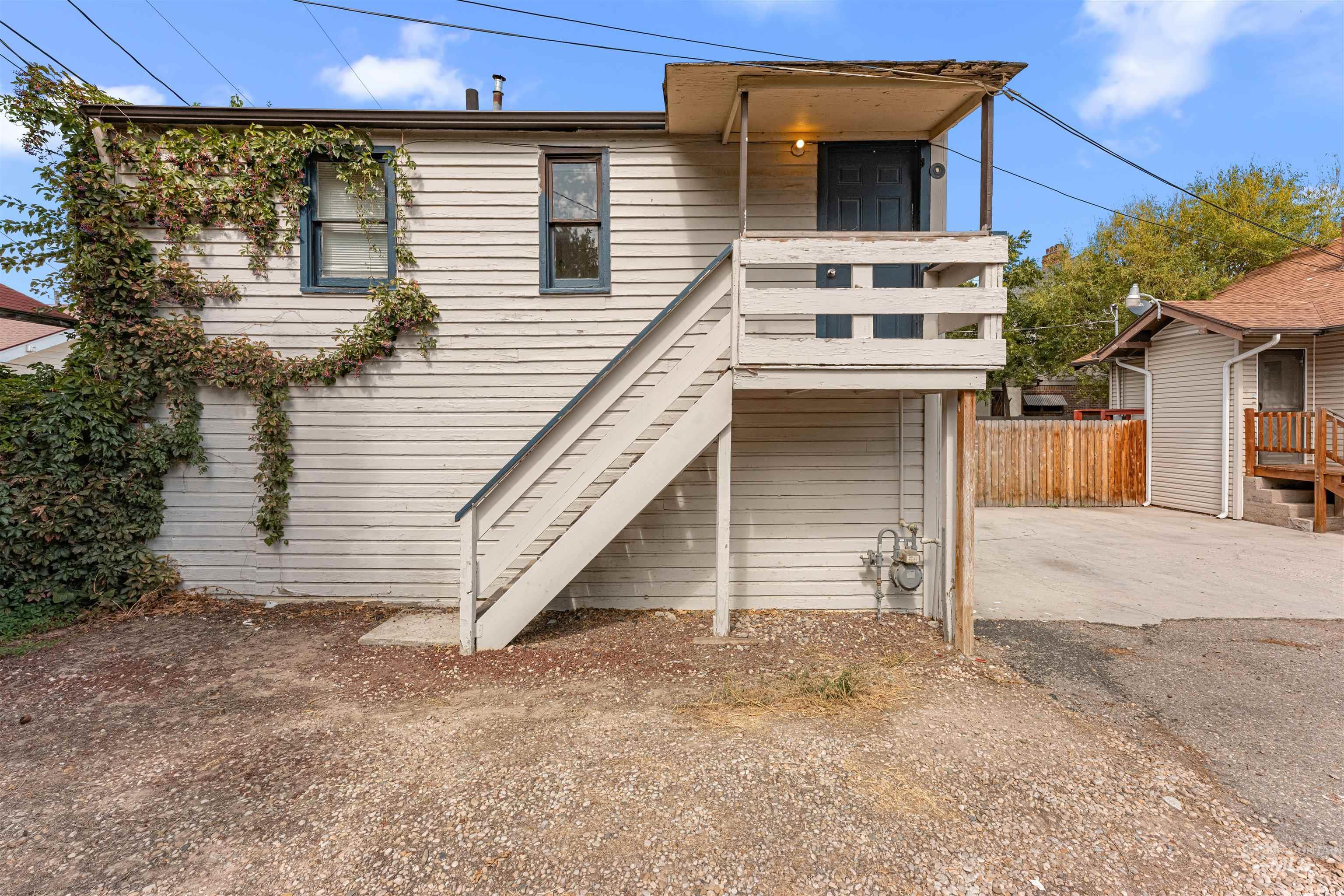 View of front of house featuring stairway and a balcony