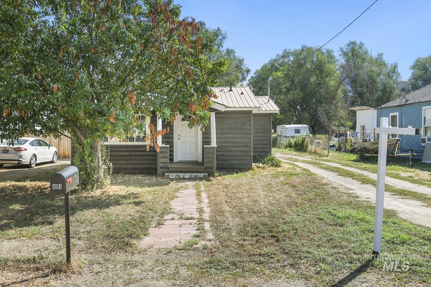 View of front of home with a metal roof and a front yard