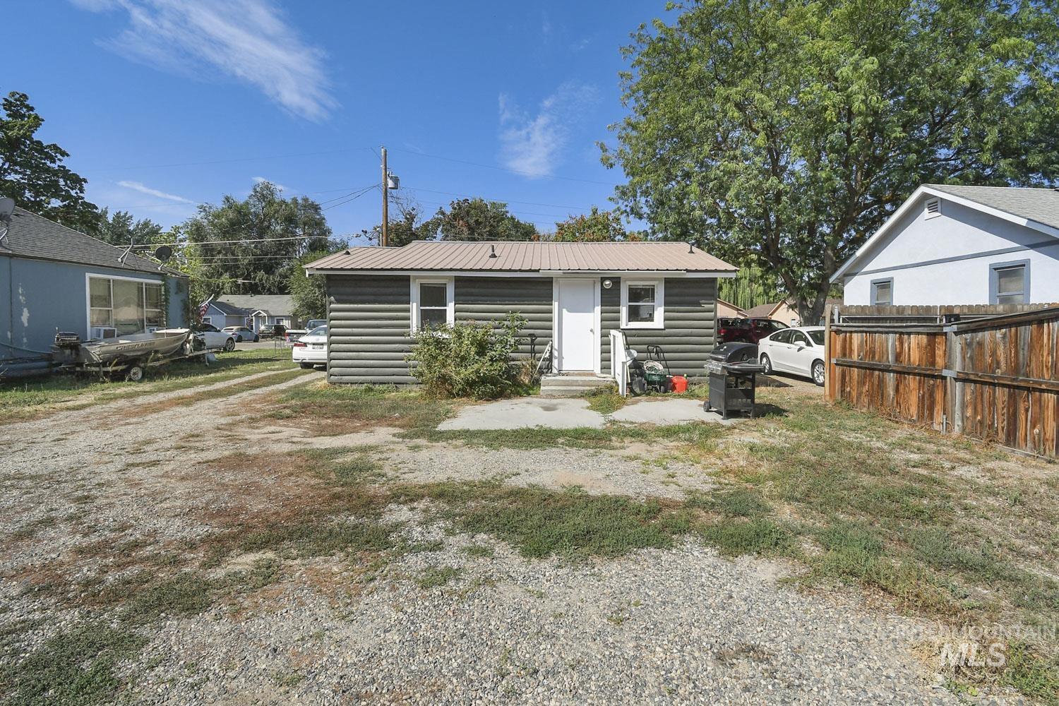 Rear view of house featuring log veneer siding, a metal roof, and entry steps