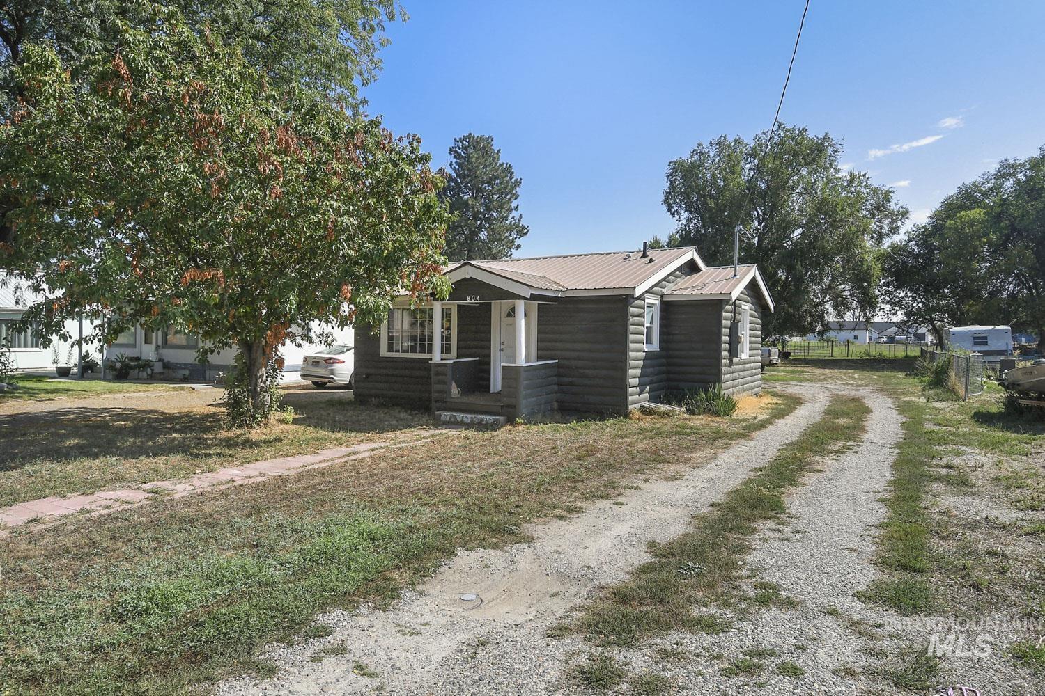 View of side of property with faux log siding, a metal roof, and driveway