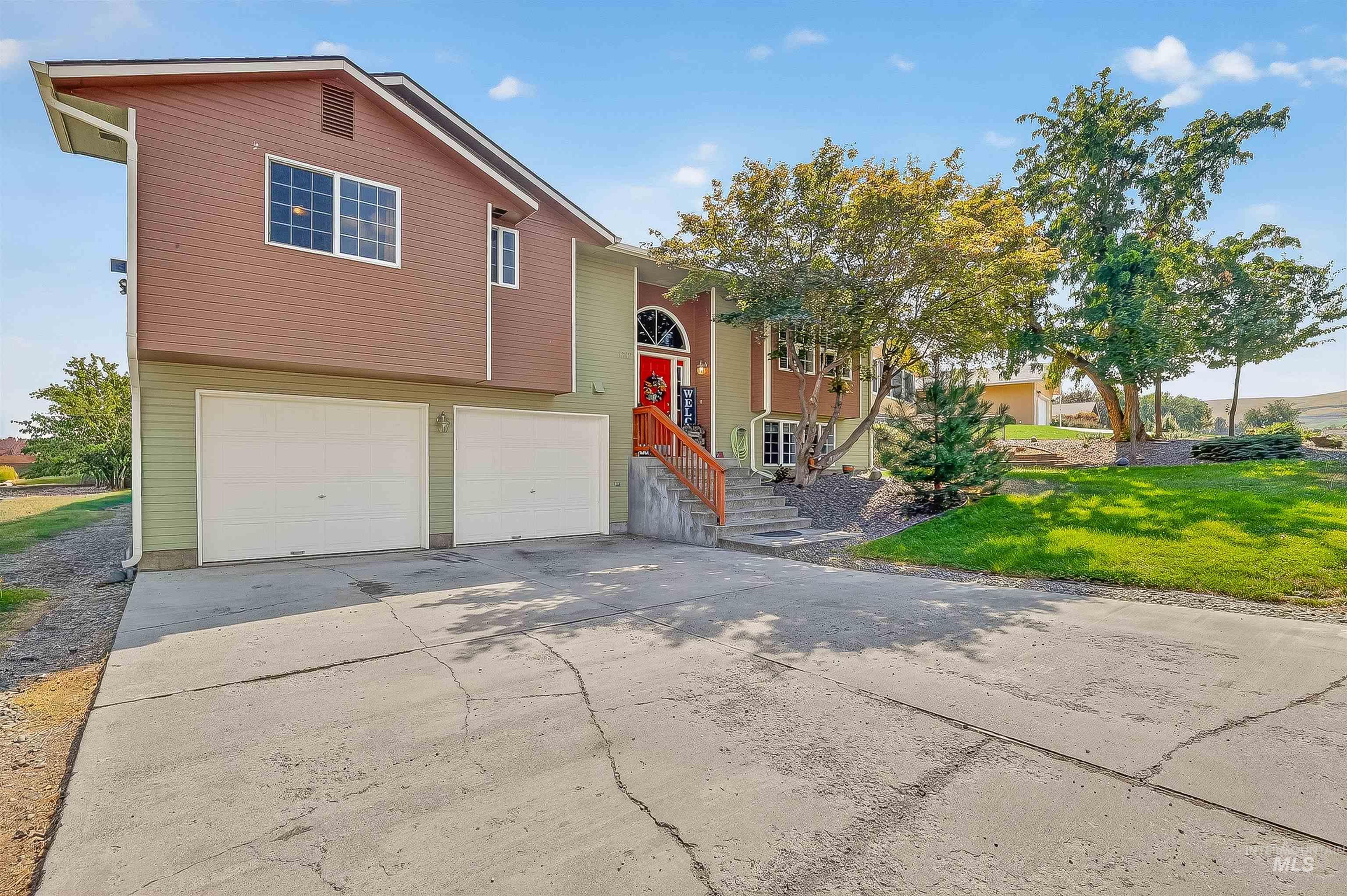 Bi-level home with a front yard, an attached garage, and driveway