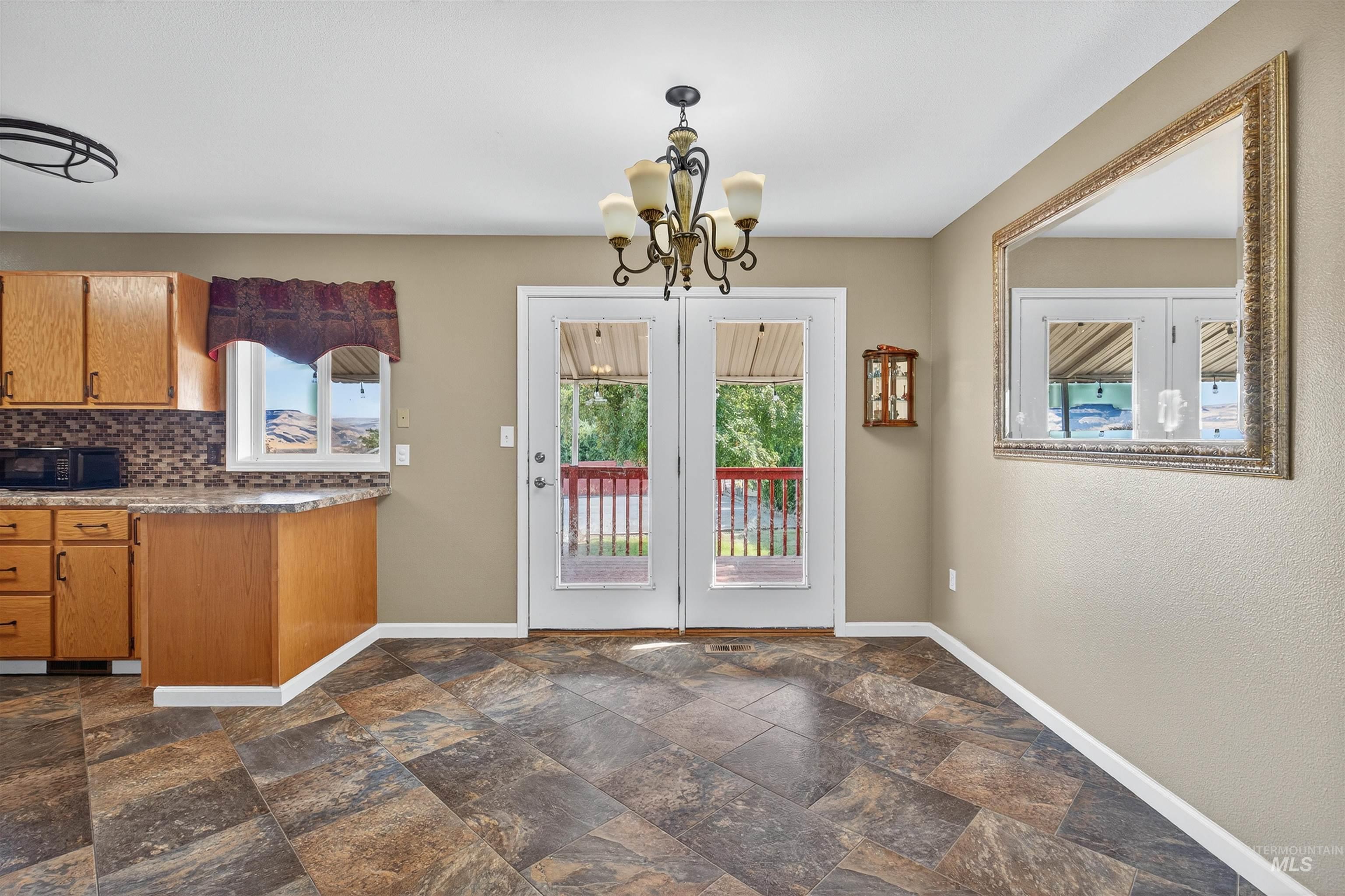 Doorway featuring a chandelier and stone finish flooring