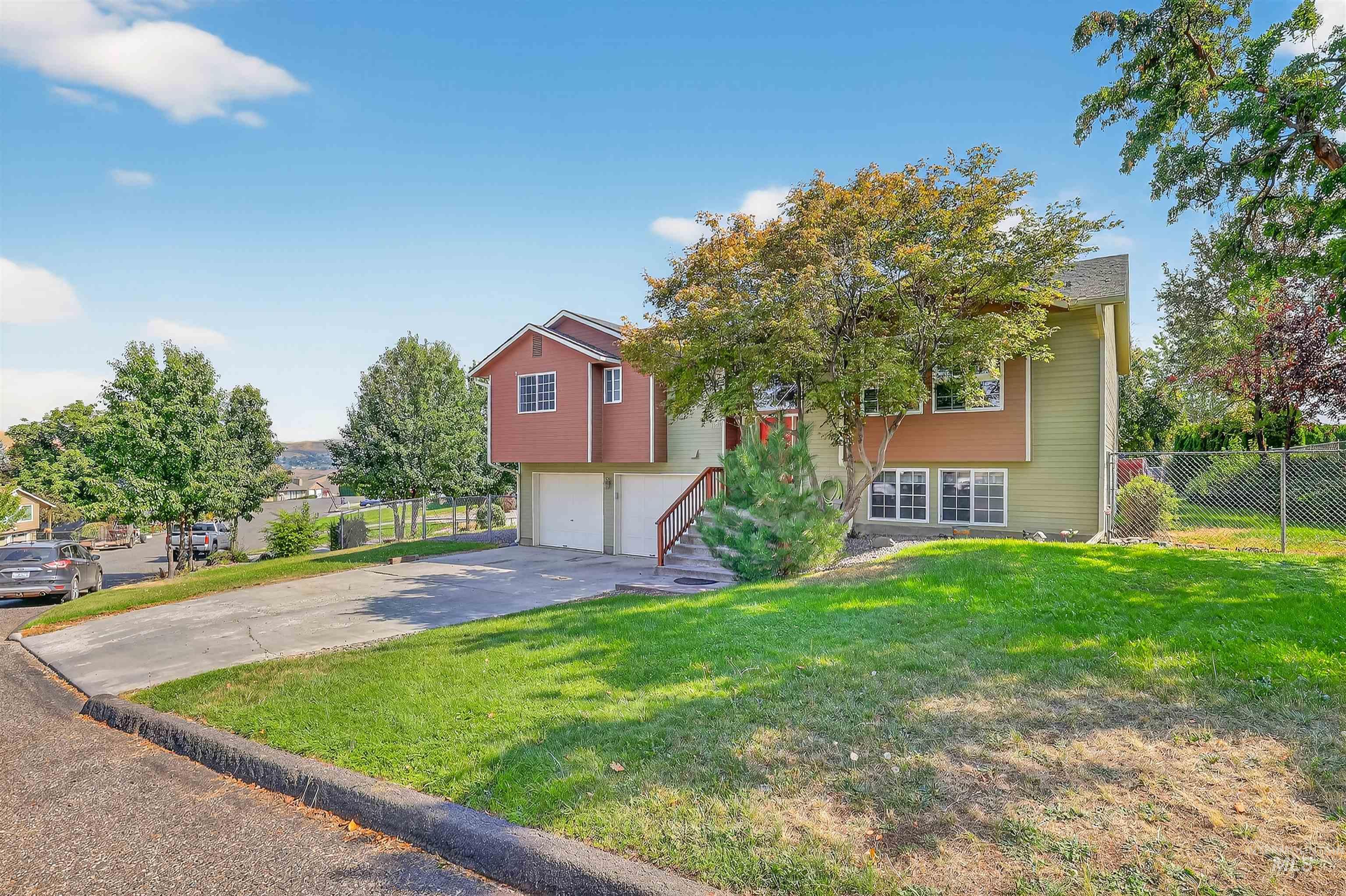Bi-level home with asphalt driveway and an attached garage