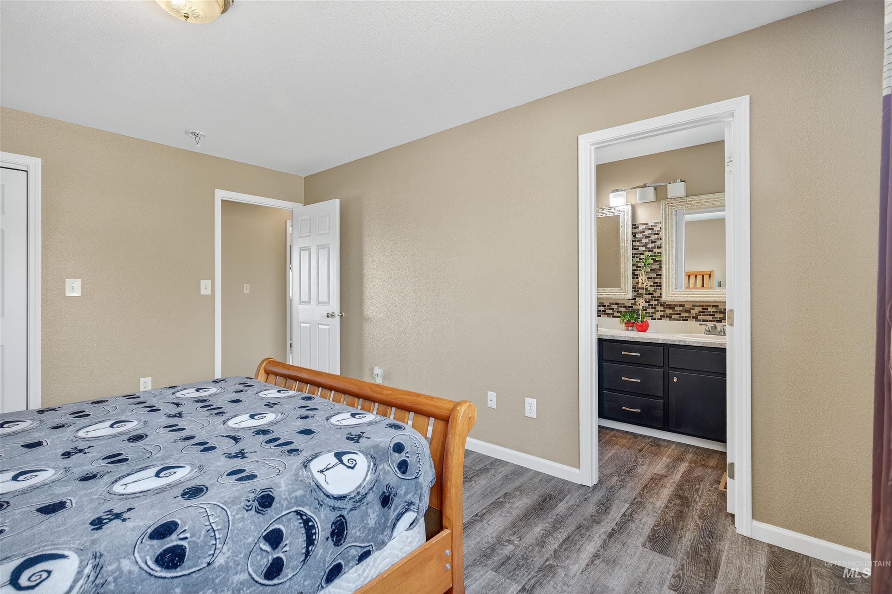 Bedroom featuring dark wood-style floors and connected bathroom