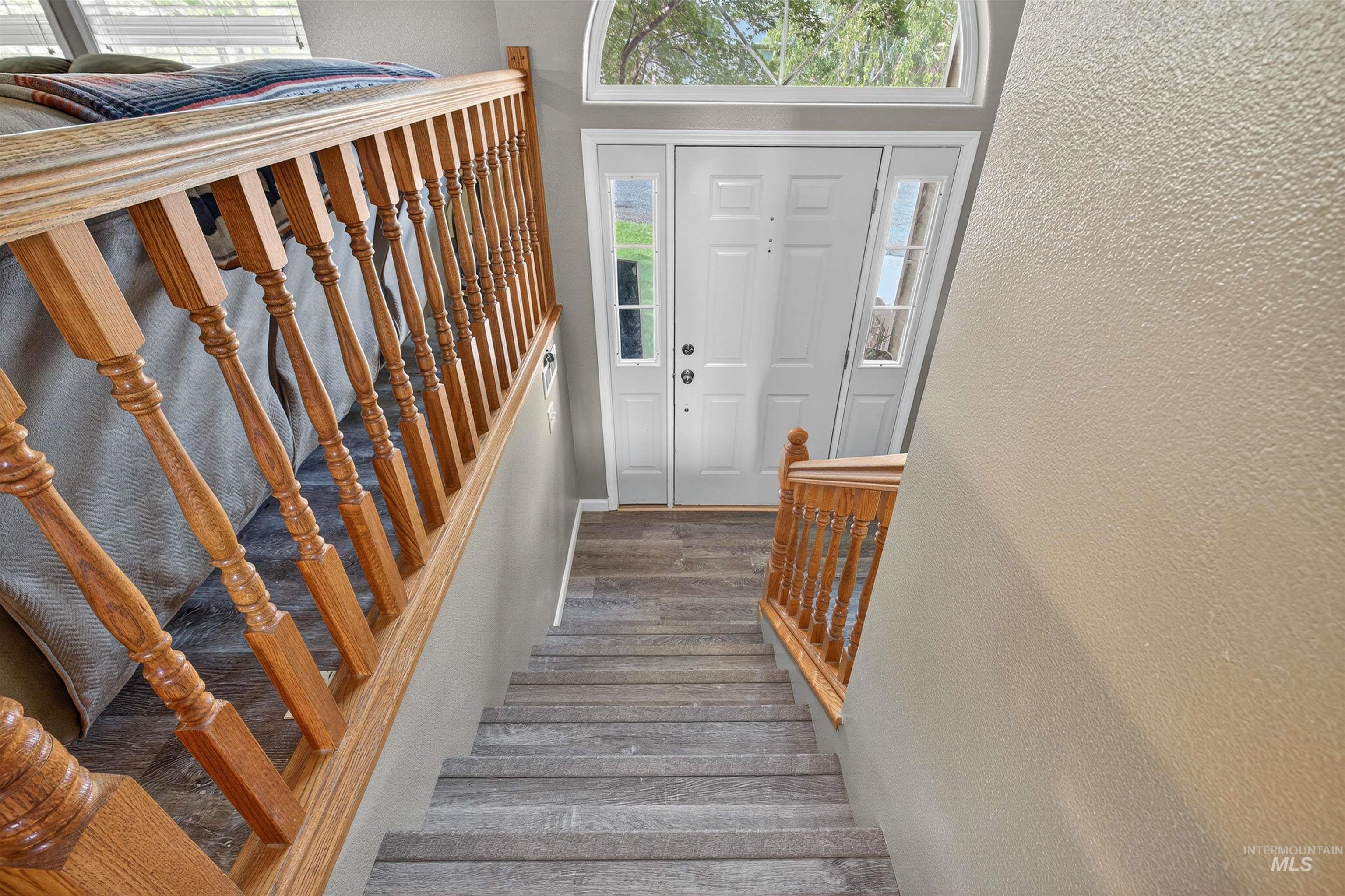 Entryway featuring stairway, a textured wall, and healthy amount of natural light