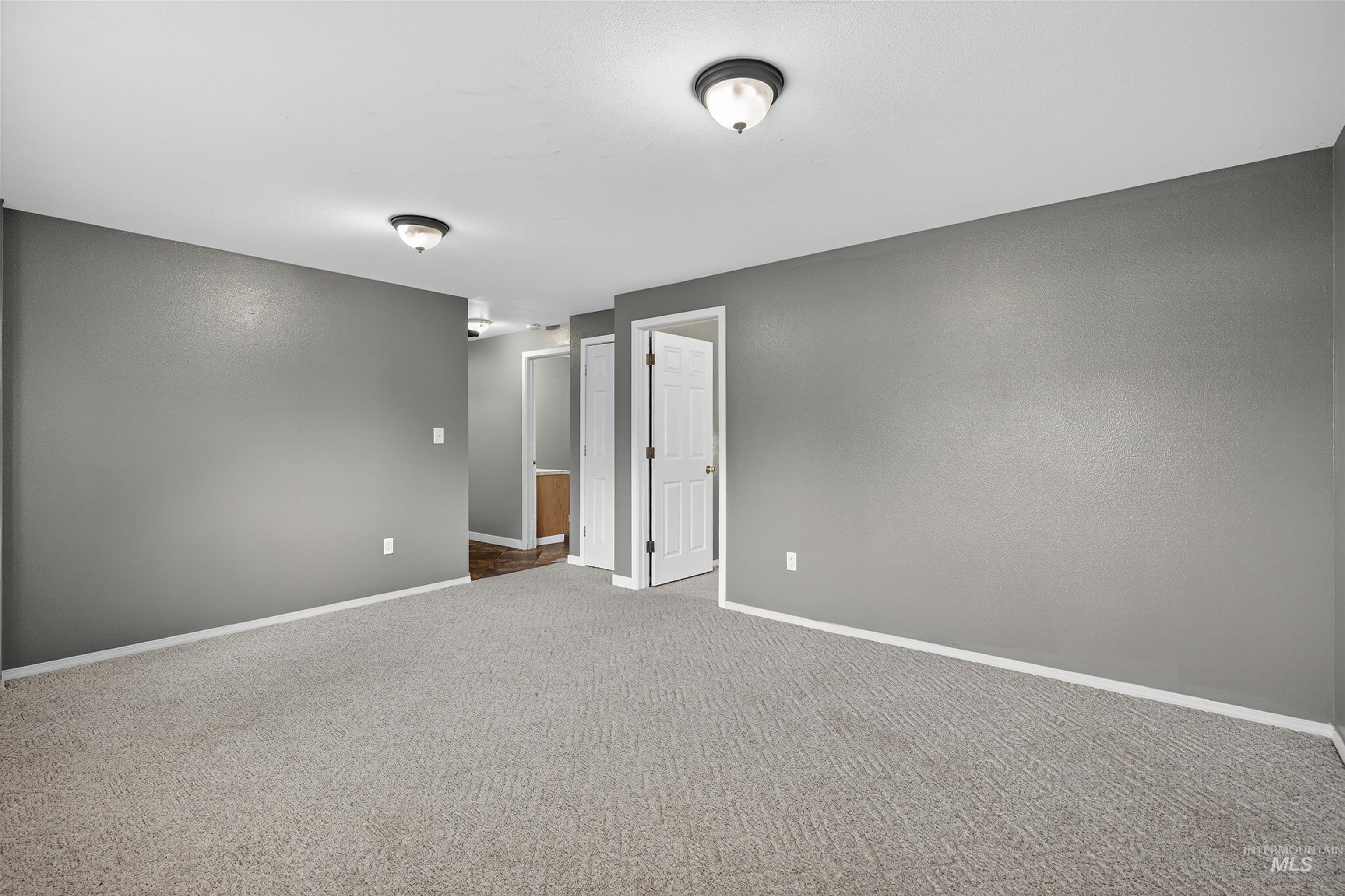 Carpeted empty room with baseboards