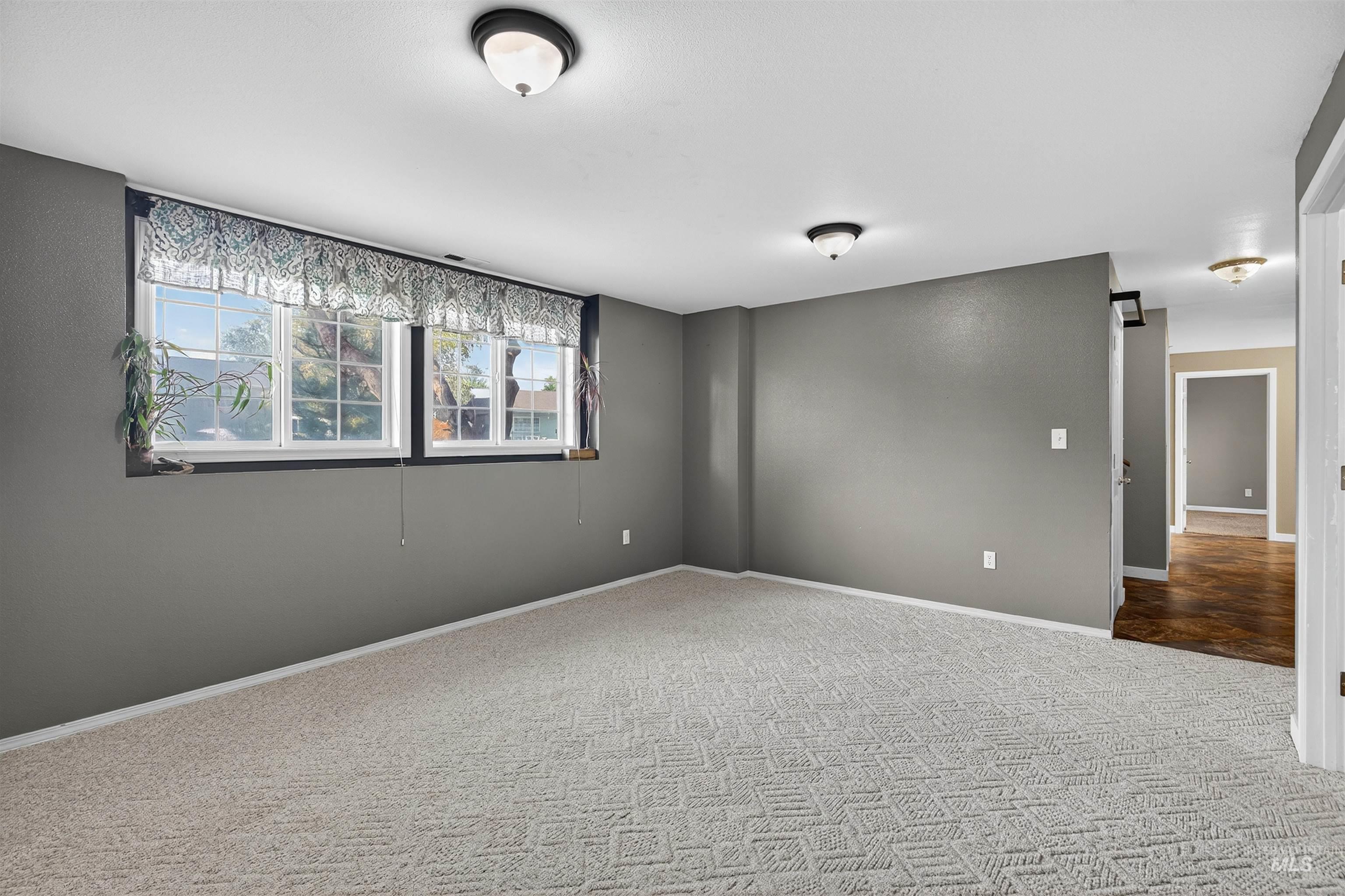 Carpeted empty room featuring baseboards