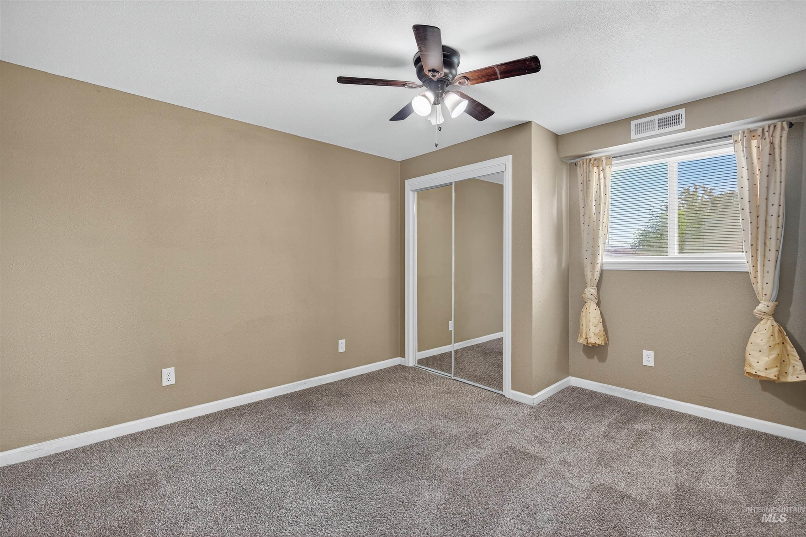 Unfurnished bedroom featuring a closet, carpet floors, and a ceiling fan
