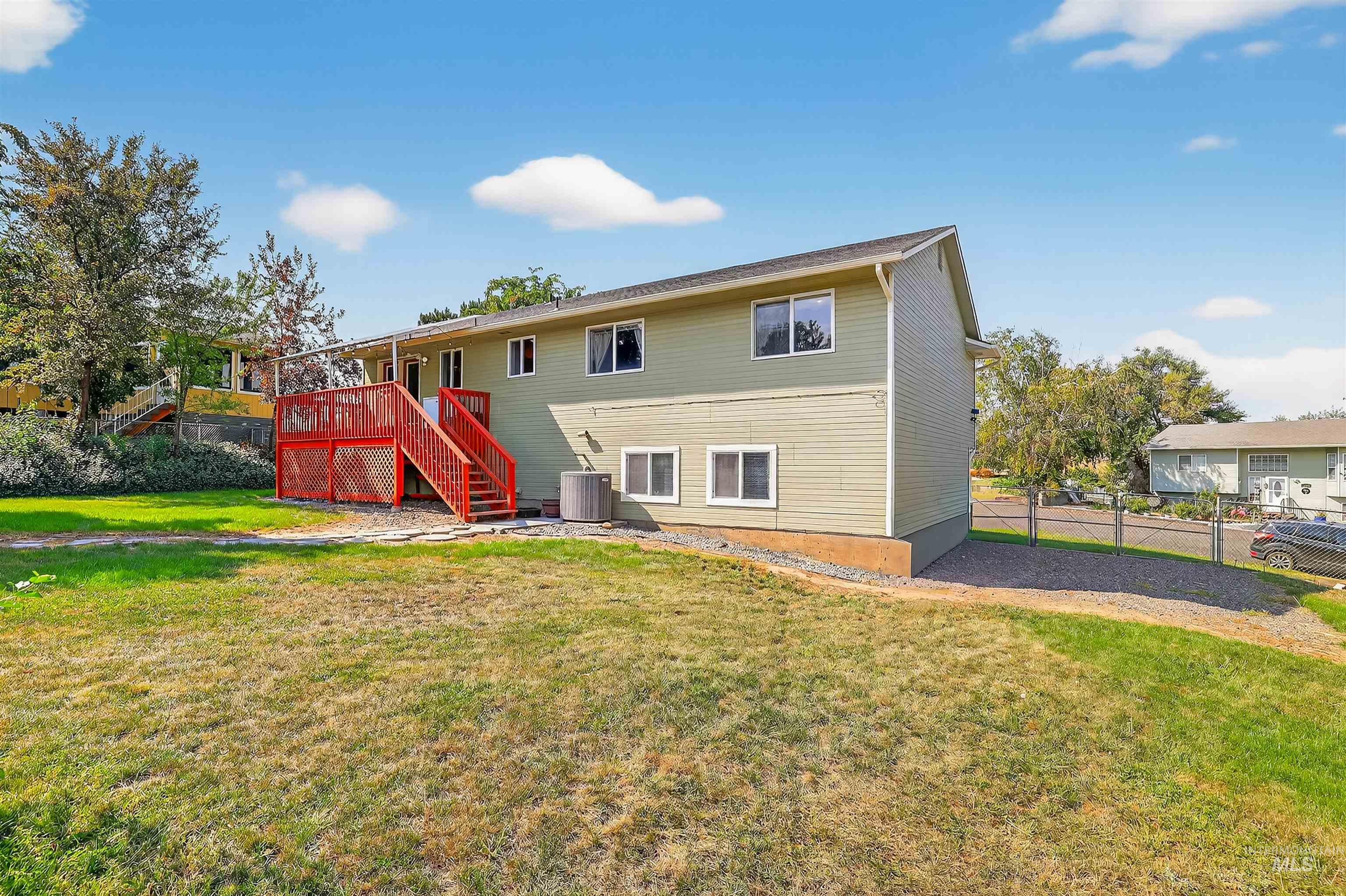 Rear view of house featuring stairs and a deck