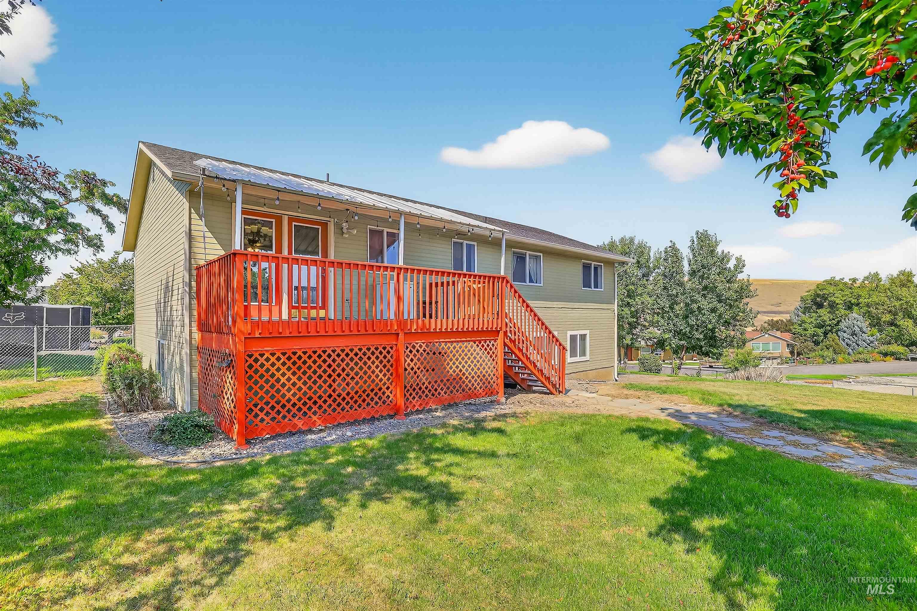 Rear view of property featuring a wooden deck and stairs