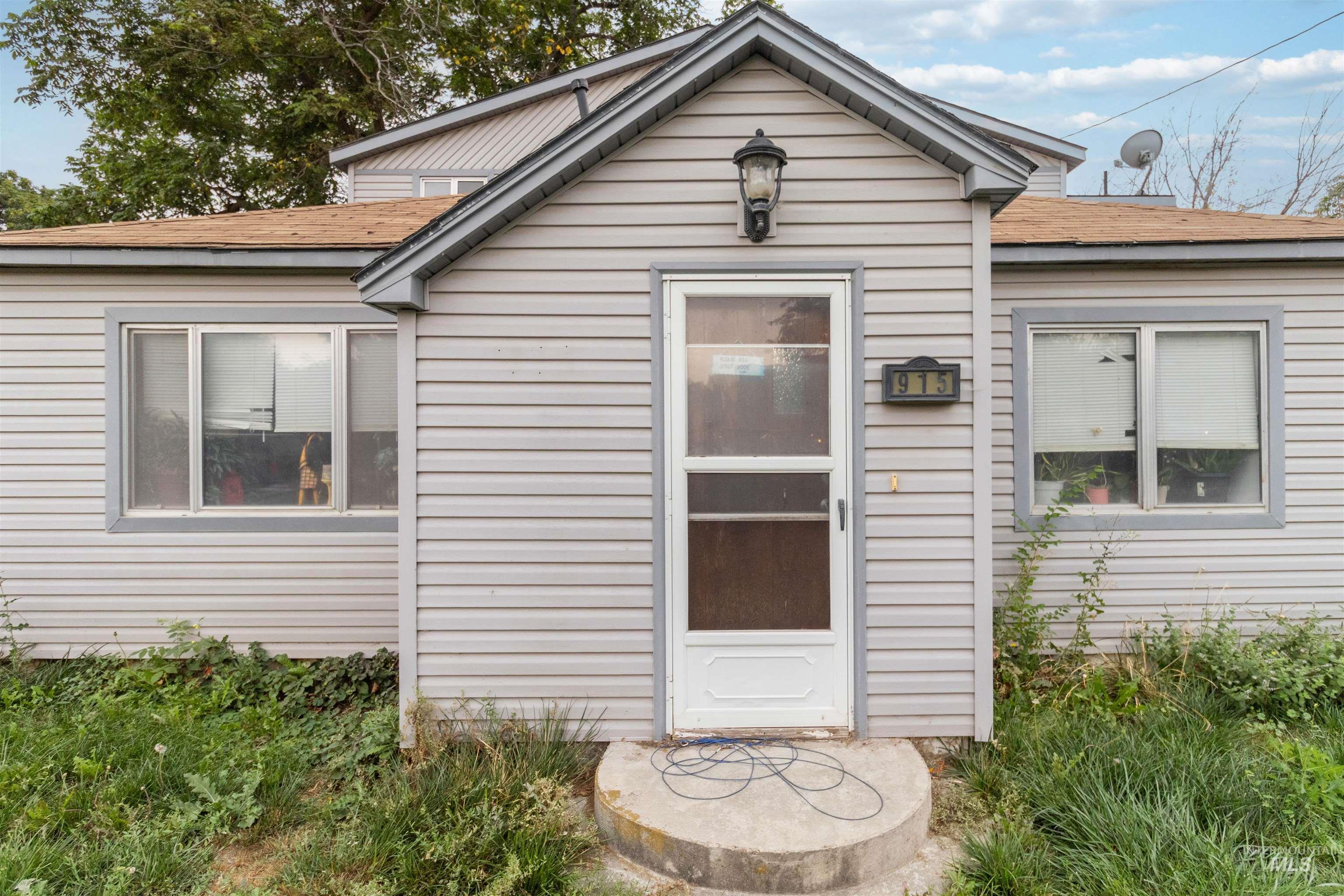 Property entrance featuring a shingled roof