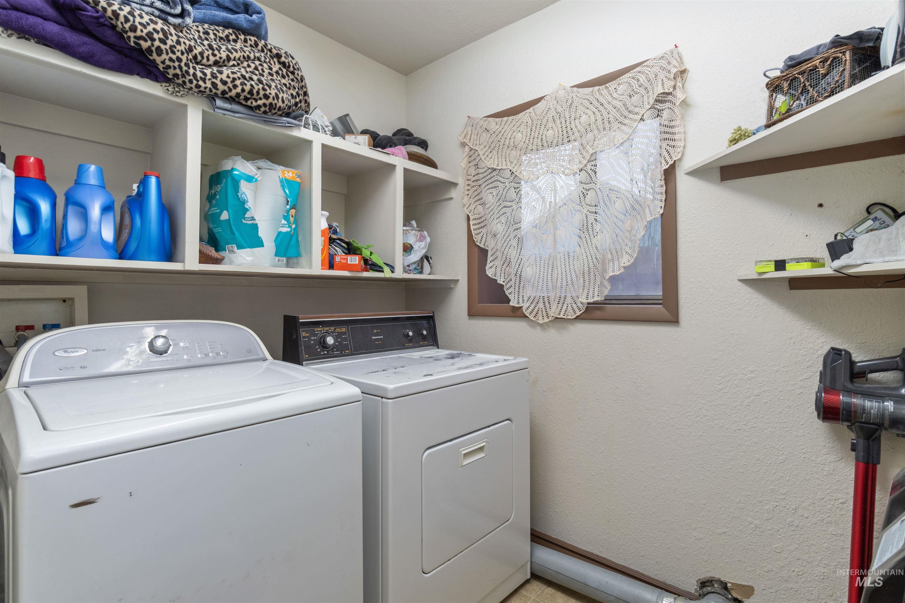 Laundry area with washer and dryer and a textured wall