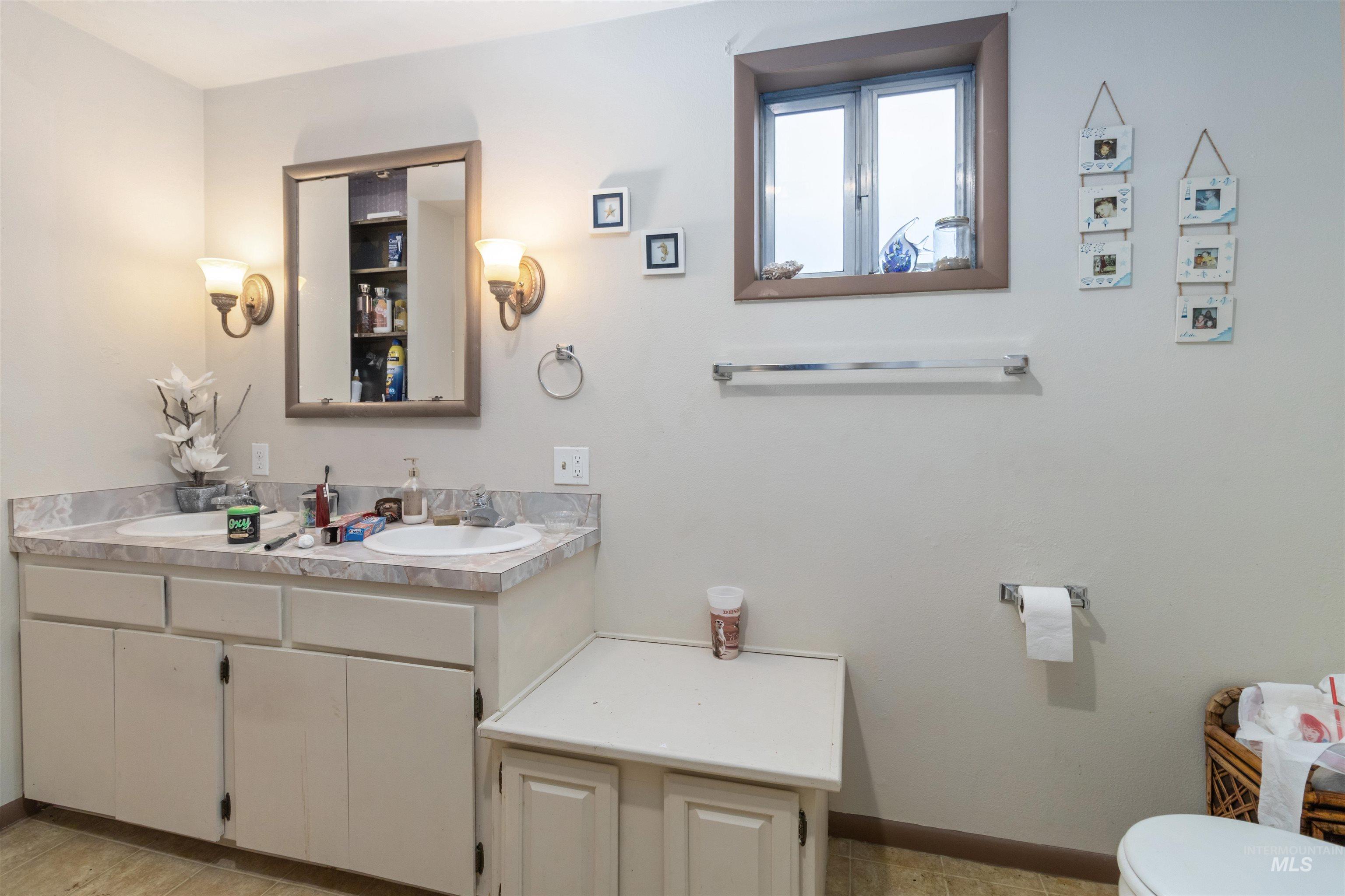Bathroom featuring double vanity and toilet