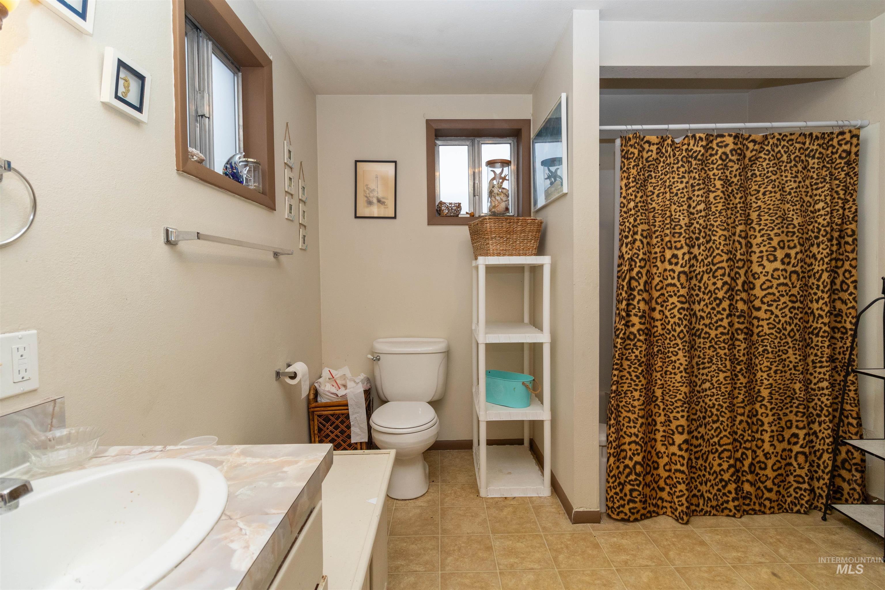 Bathroom featuring vanity, light tile patterned floors, and a stall shower