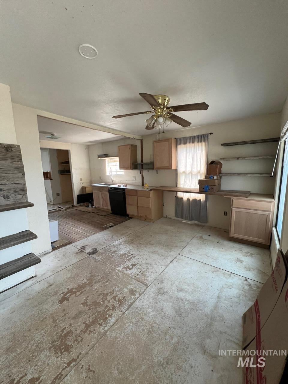 Kitchen with light brown cabinets, dishwasher, and ceiling fan