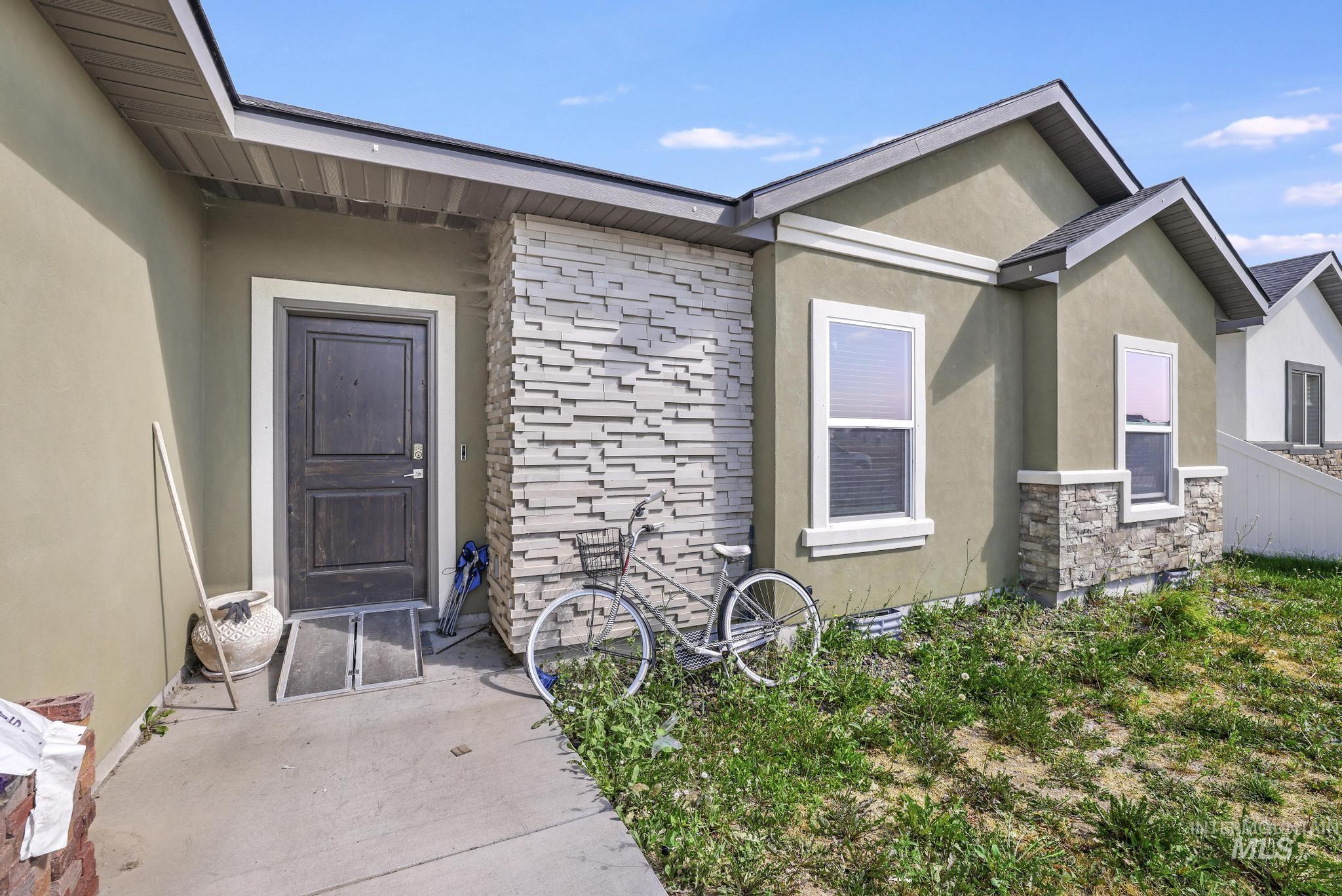 Property entrance with stone siding and stucco siding