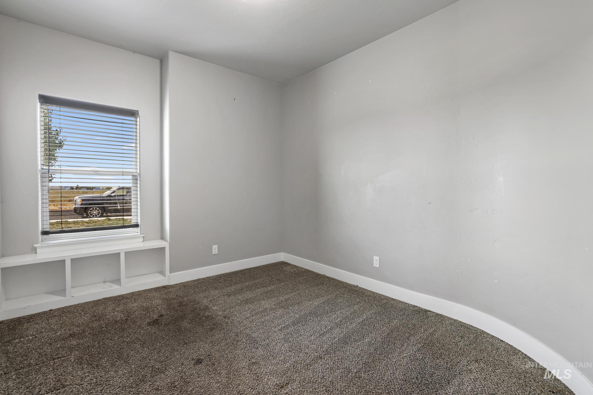 Carpeted empty room featuring baseboards