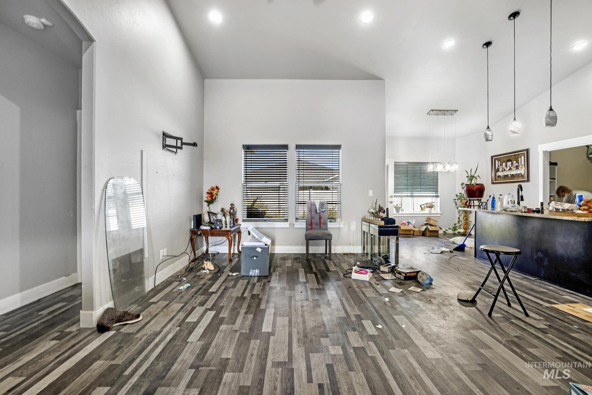 Living room with recessed lighting, a towering ceiling, and dark wood-type flooring
