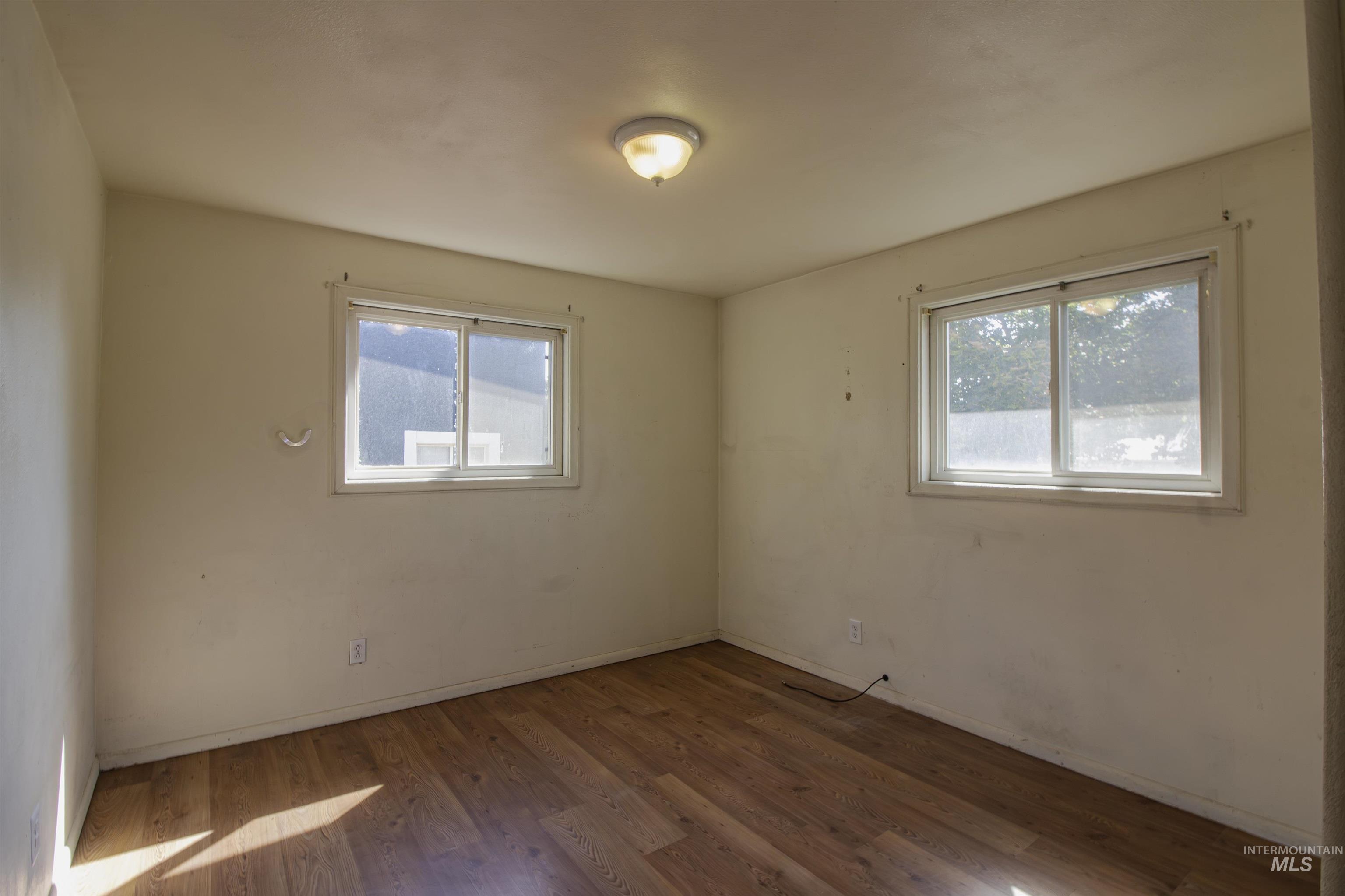 Empty room featuring plenty of natural light and wood finished floors