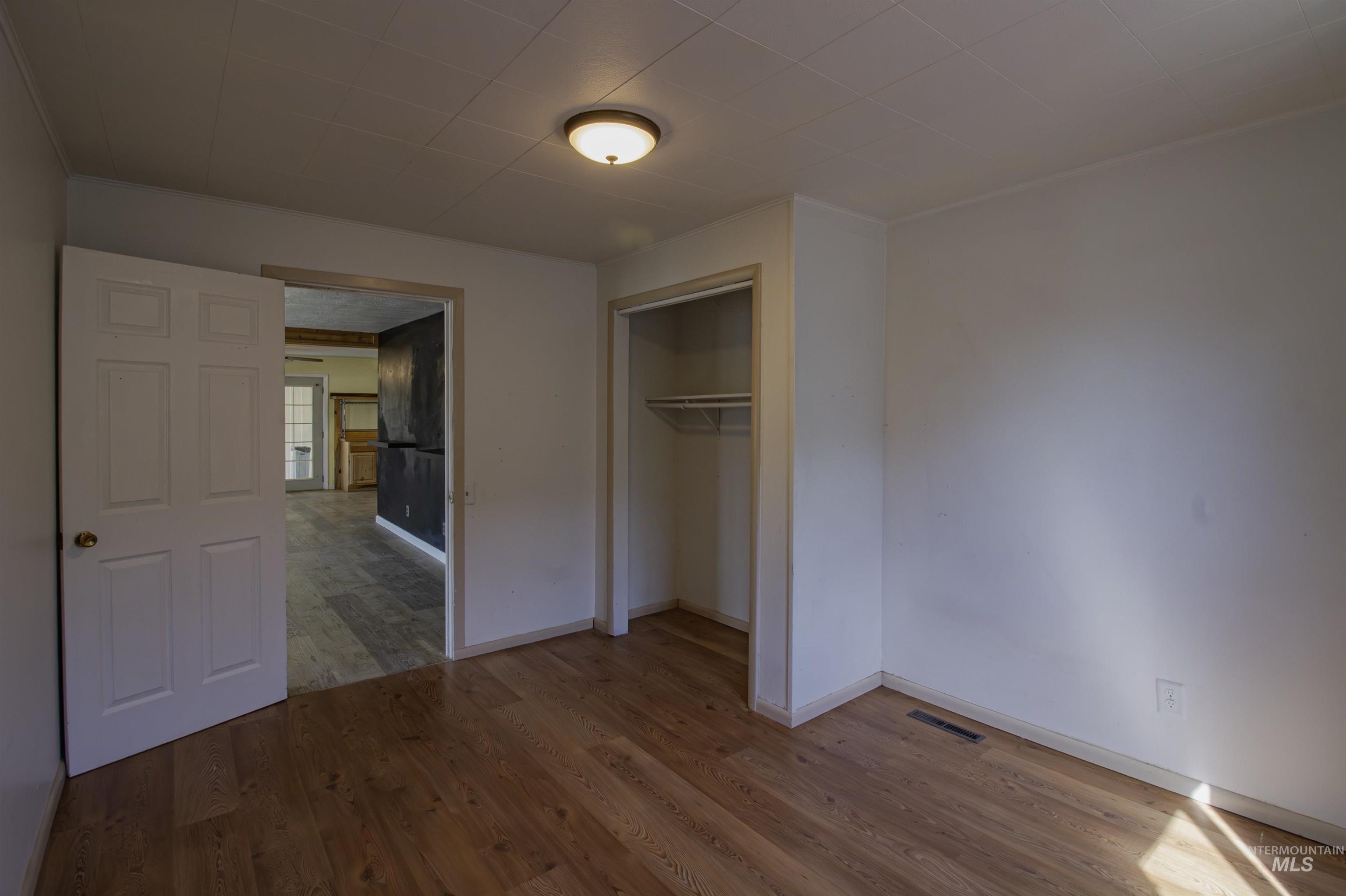 Unfurnished bedroom featuring light wood-type flooring and a closet