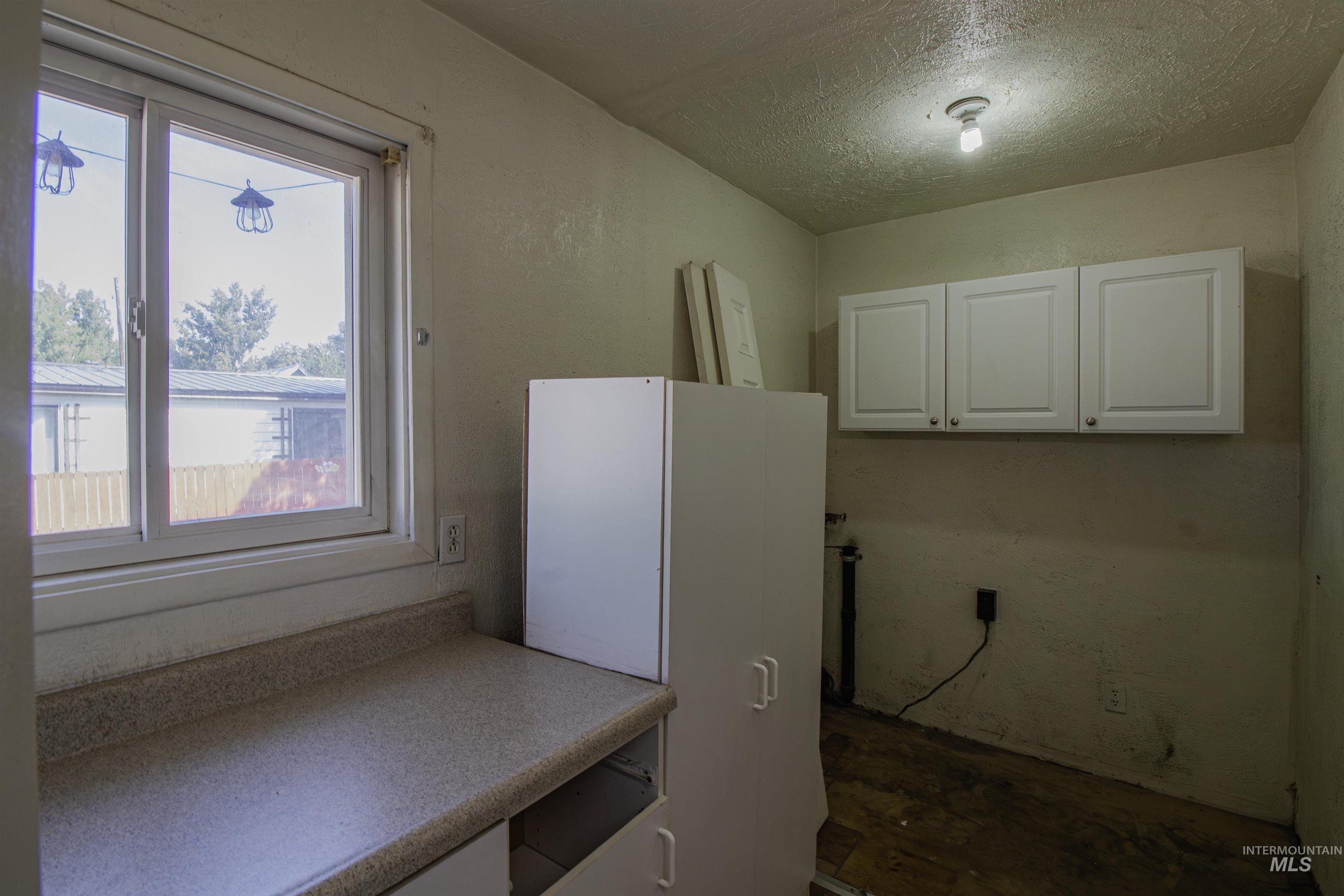 Laundry area with a textured ceiling
