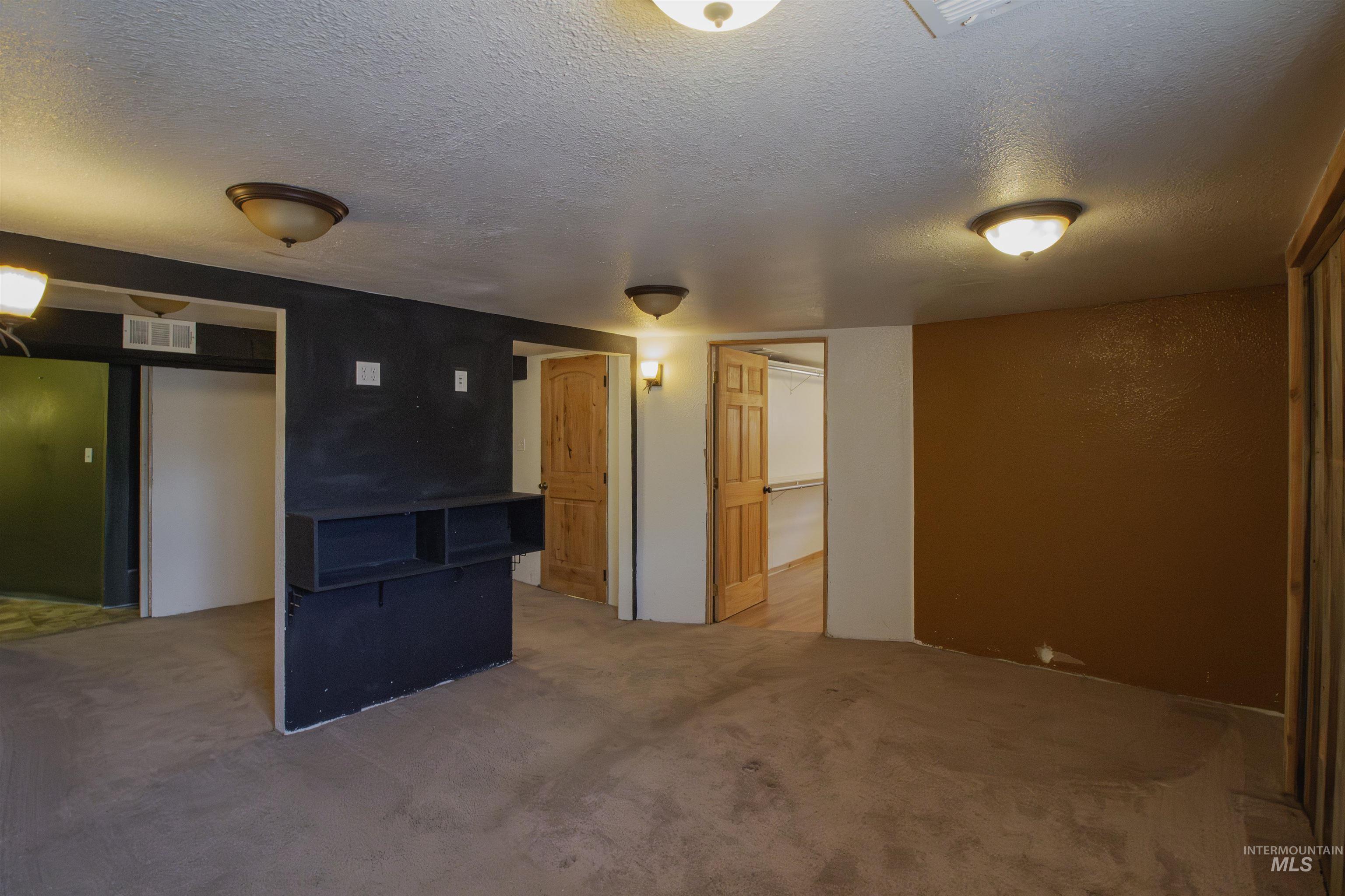 Below grade area with a textured ceiling and carpet