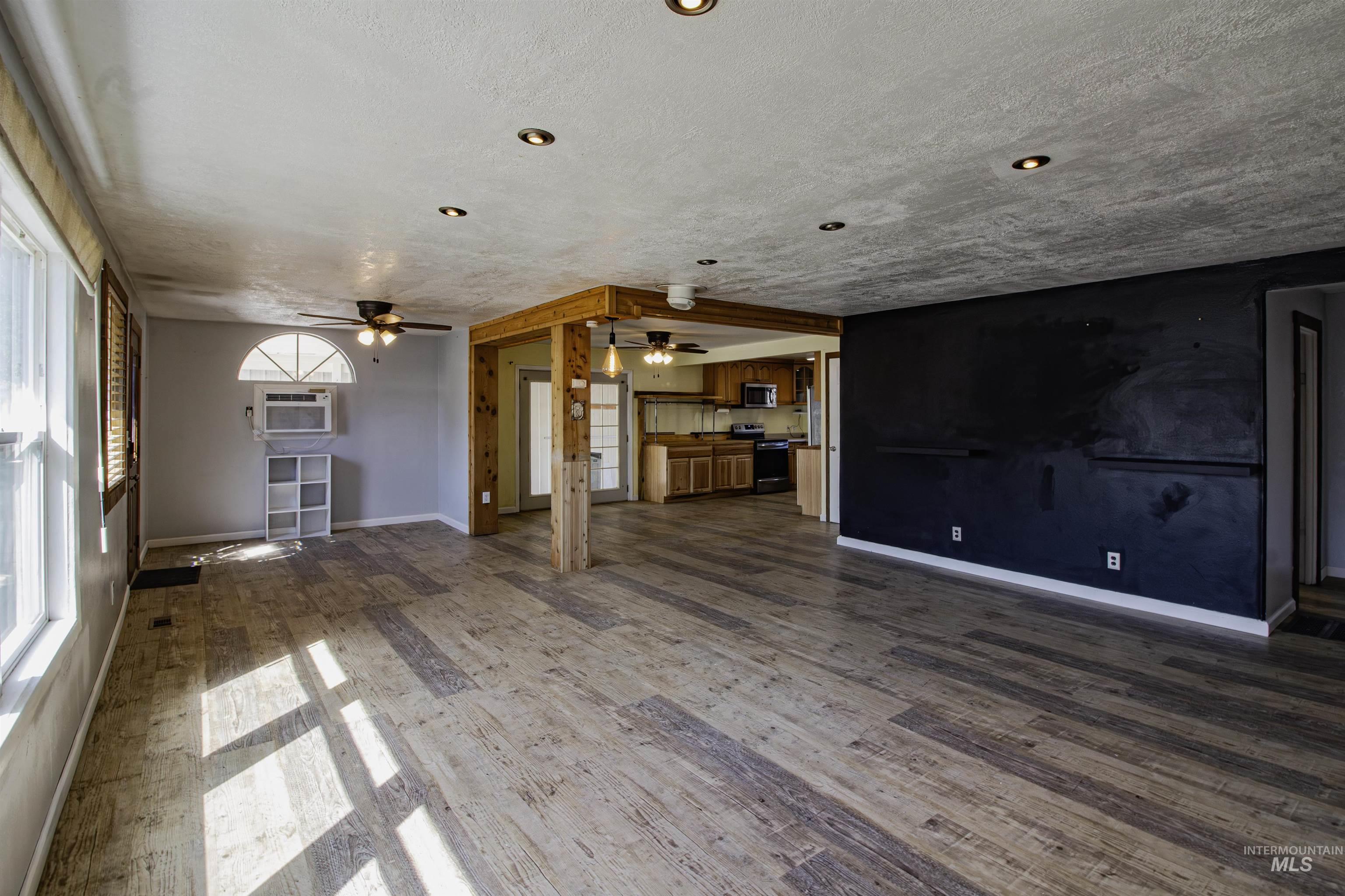 Unfurnished living room with dark wood finished floors and a textured ceiling